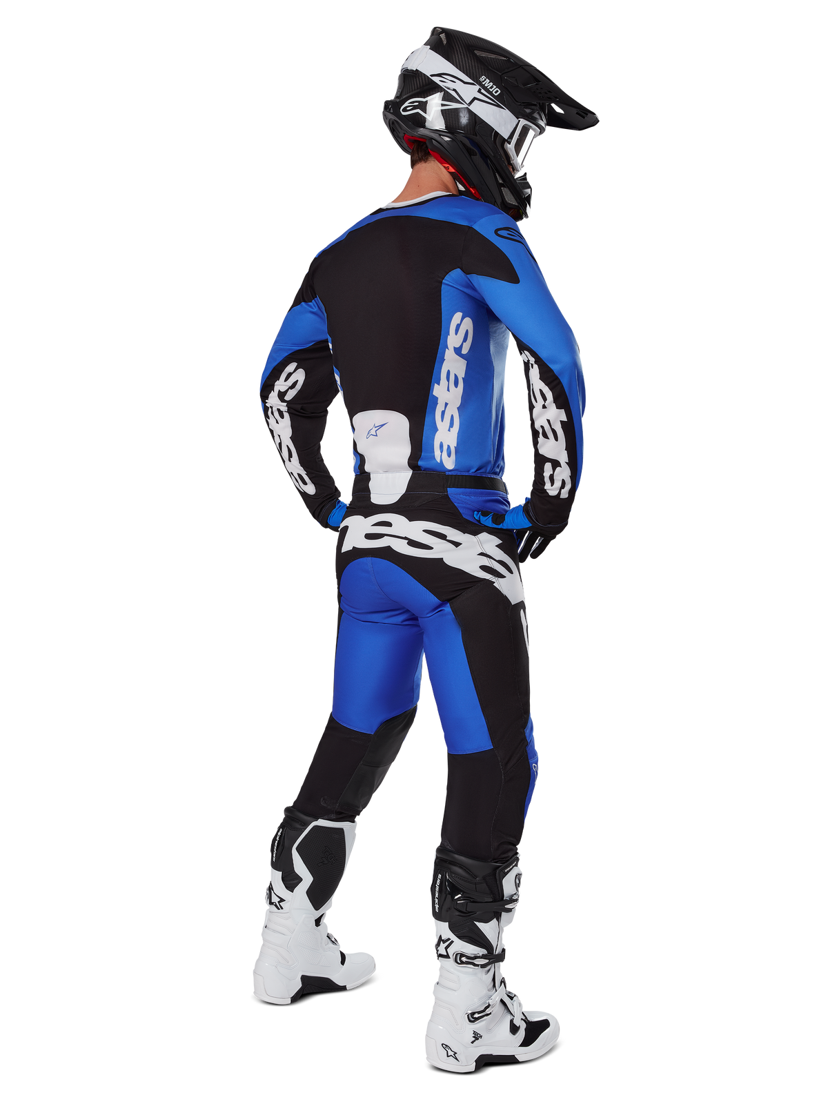 Pilota di motocross con abbigliamento completo da gara visto da dietro, maglia Racer Veil 2025 e pantaloni abbinati in blu e nero, con loghi Alpinestars bianchi, casco nero, stivali bianchi e neri, completo coordinato per gare off-road