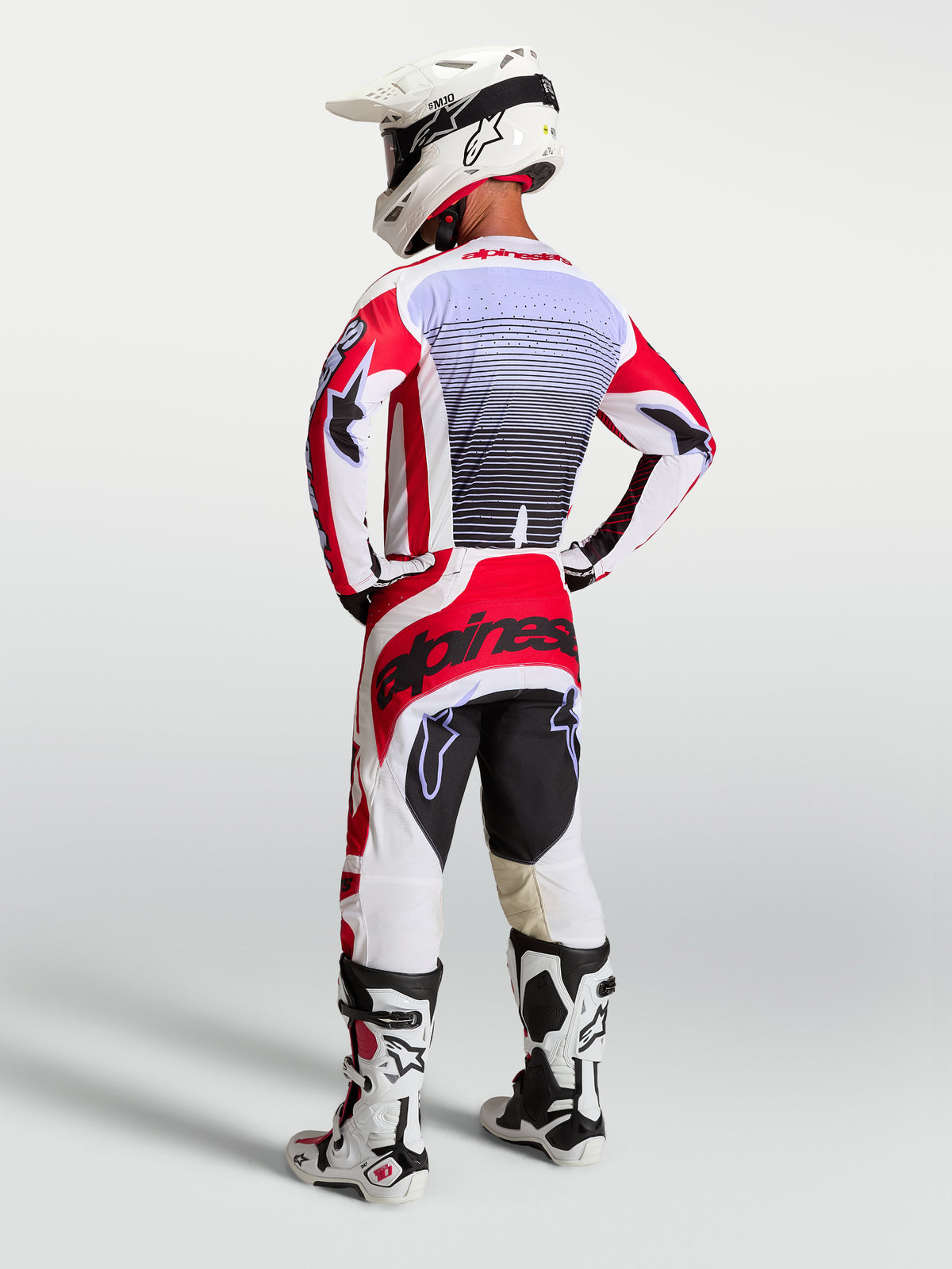 Alpinestars maglia Techstar Maven, completo da motocross bianco e rosso, uomo, vista posteriore atletica e dettagli lavanda.