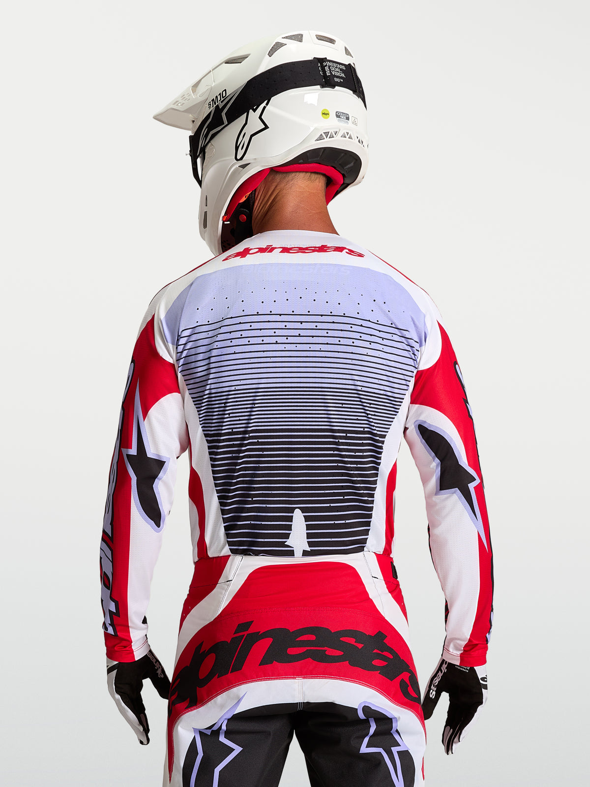 Alpinestars maglia Techstar Maven, maglia da motocross uomo rosso fuoco e bianca, traspirante, vista posteriore su pilota.