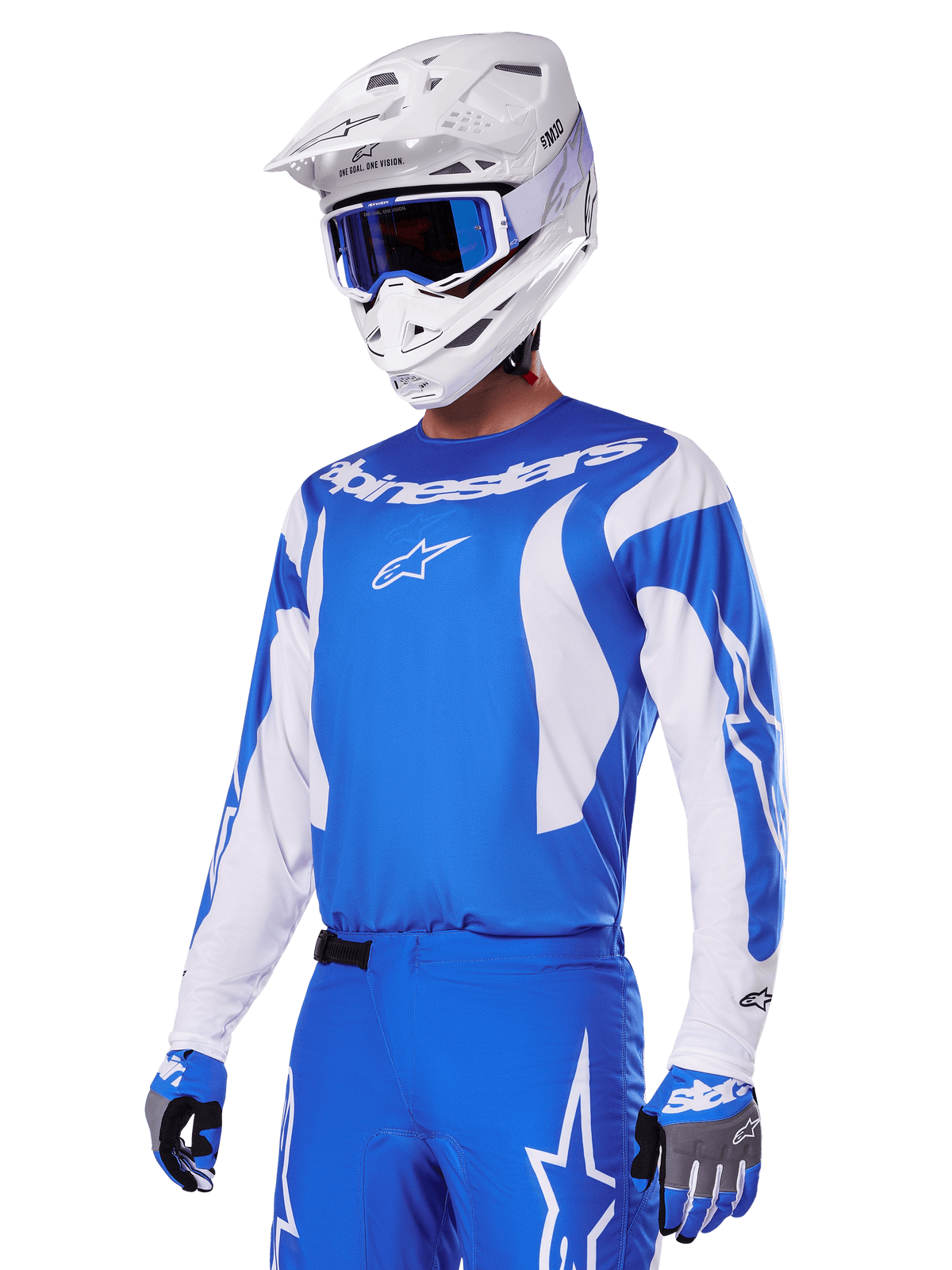 Pilota di motocross che indossa il set di abbigliamento Alpinestars 2025 Fluid Haul in blu e bianco, con maglia blu e accenti bianchi, pantaloni blu coordinati con loghi a stella, casco bianco con occhiali blu e guanti coordinati blu e grigi, outfit completo da gara off-road.