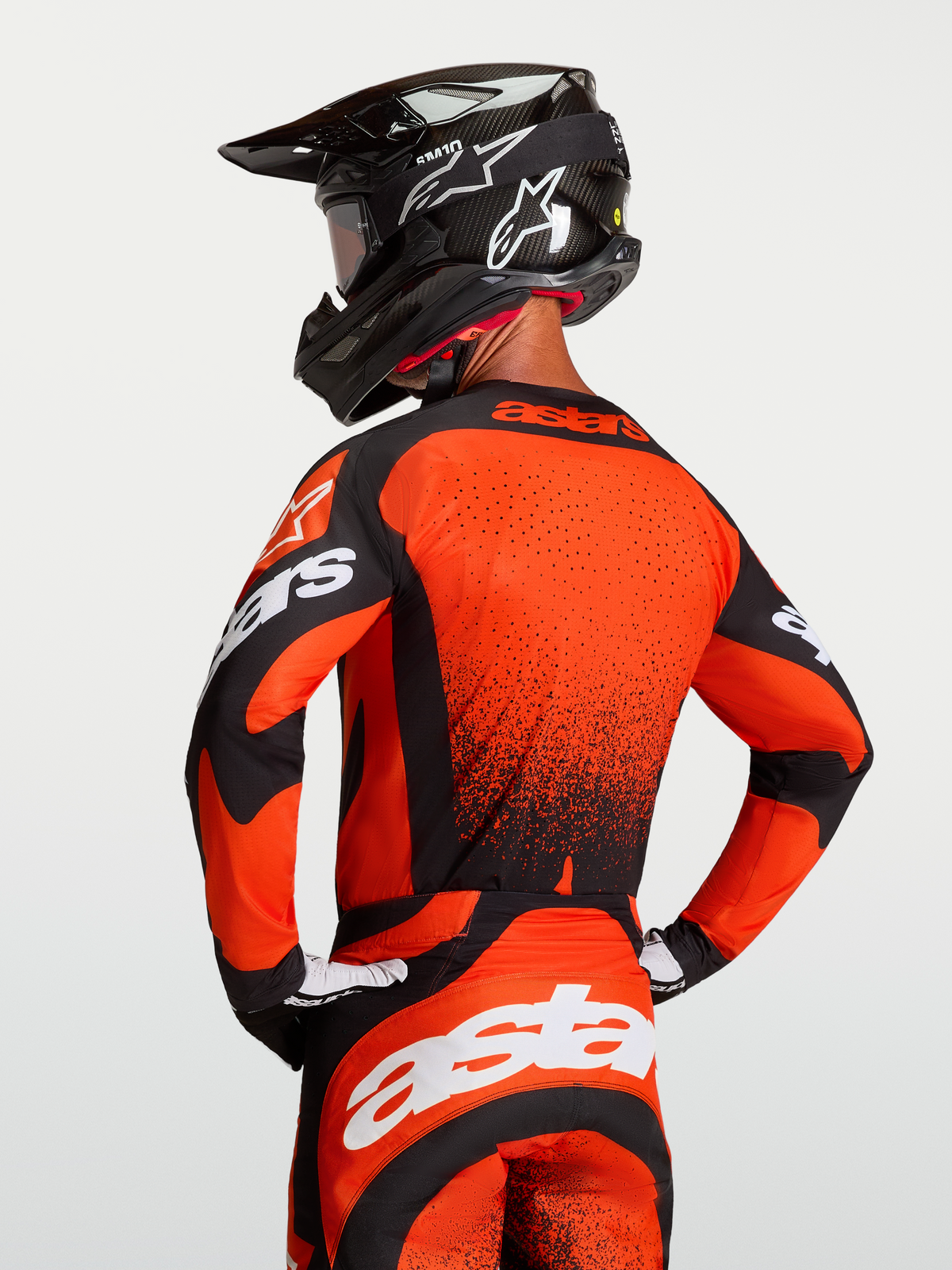 Alpinestars Maglia Techstar Swan, maglia da motocross da uomo, rosso cardinale e nero, con ventilazione laser-cut e vestibilità atletica da gara, indossata con casco e maschera coordinati, ideale per l'off-road e il motocross