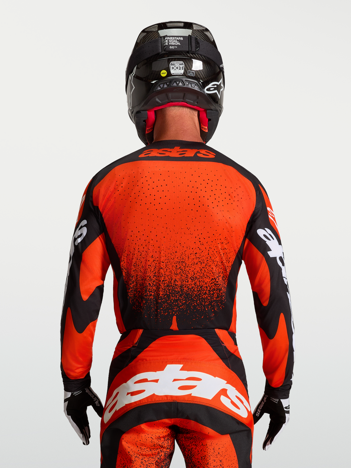 Alpinestars Maglia Techstar Swan, maglia motocross rossa e nera, vista posteriore su modello, orlo allungato con perforazioni laser, stile racing