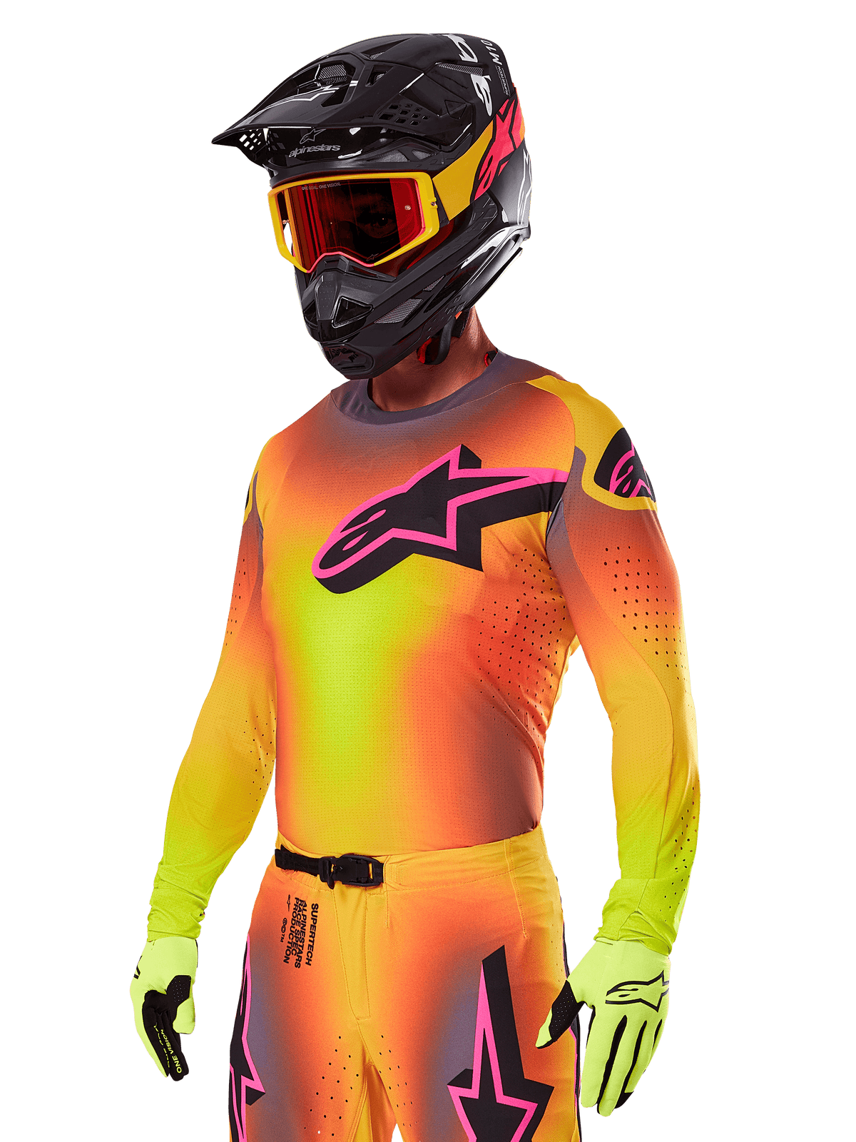 Pilota di motocross con Set Gear Alpinestars Supertech Lipan 2025, maglia con sfumatura gialla e arancione e logo Astars rosa e nero, guanti giallo neon, casco nero con occhiali rossi, abbigliamento professionale da gara fuoristrada