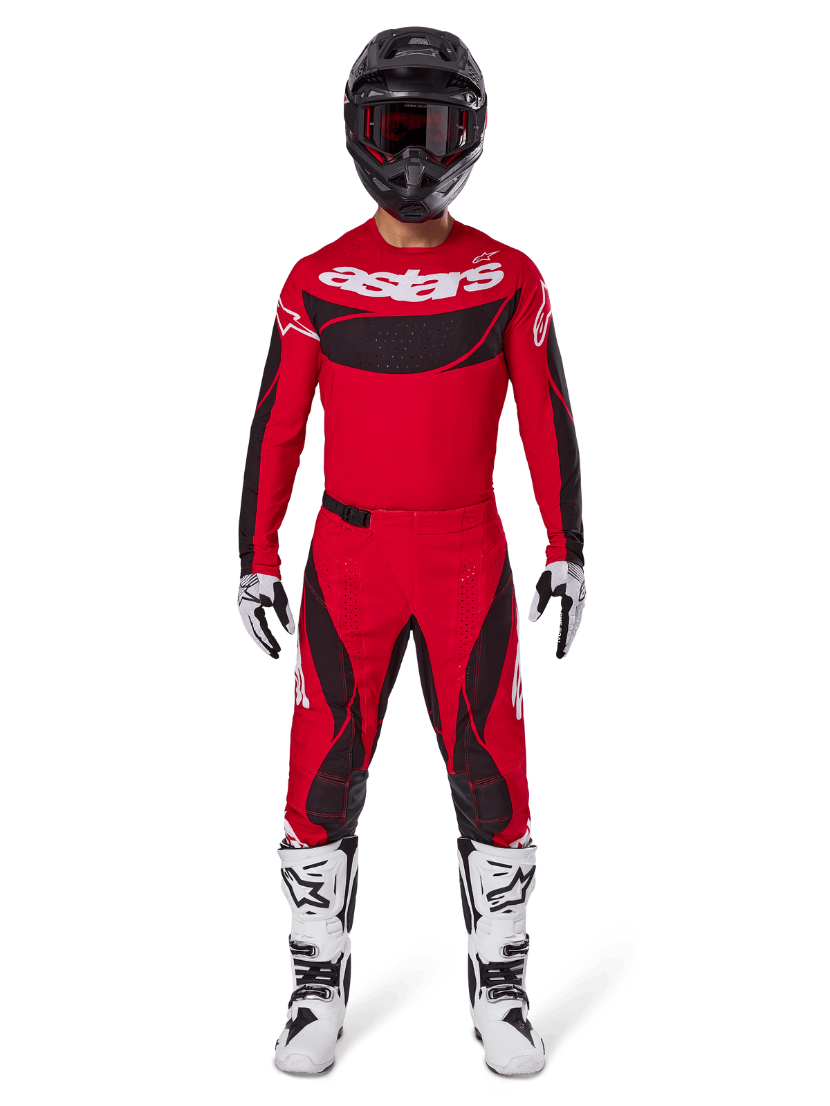 Pilota di motocross che indossa il set completo Alpinestars 2025 Techstar Dreem, maglia rosso acceso con pannelli neri e marchio 'astars' bianco, pantaloni coordinati rossi e neri, casco nero, stivali e guanti bianchi e neri, abbigliamento completo per competizioni off-road