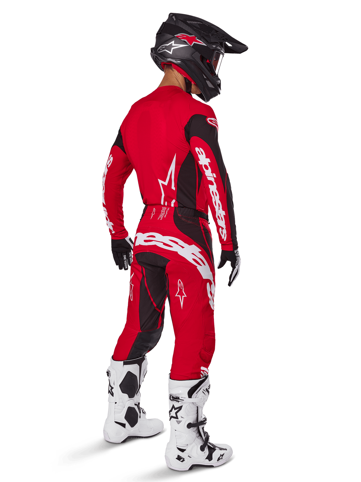Pilota di motocross che indossa il set completo Alpinestars Techstar Dreem 2025 in rosso acceso e nero, con loghi bianchi su maglia e pantaloni, abbinato a casco nero, stivali bianchi e neri e guanti neri e bianchi, vista posteriore di tre quarti.