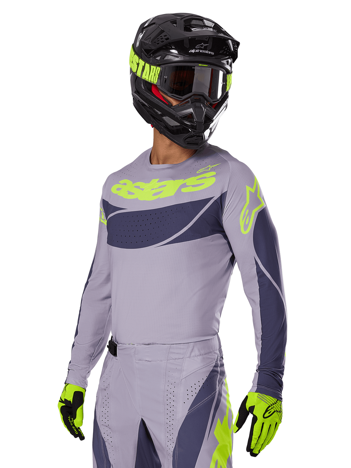 Pilota di motocross che indossa la maglia Alpinestars 2025 Techstar Dreem in grigio e grigio scuro, con logo 'astars' giallo neon sul petto, completata da casco, maschera e guanti coordinati per un look da gara off-road.
