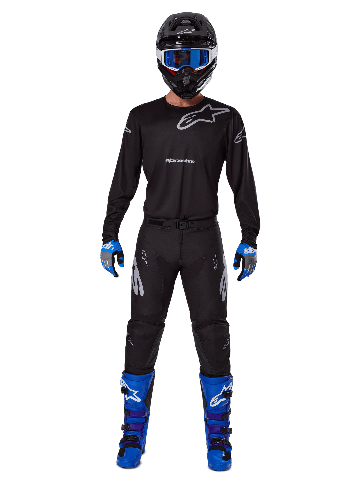 Alpinestars 2025 Racer Graphite Gear Set, pilota di motocross con abbigliamento completo da gara, maglia nera a maniche lunghe con loghi Alpinestars grigi, pantaloni neri, casco nero con occhiali blu, guanti blu e grigi, stivali blu e neri, outfit coordinato per gare di motocross fuoristrada