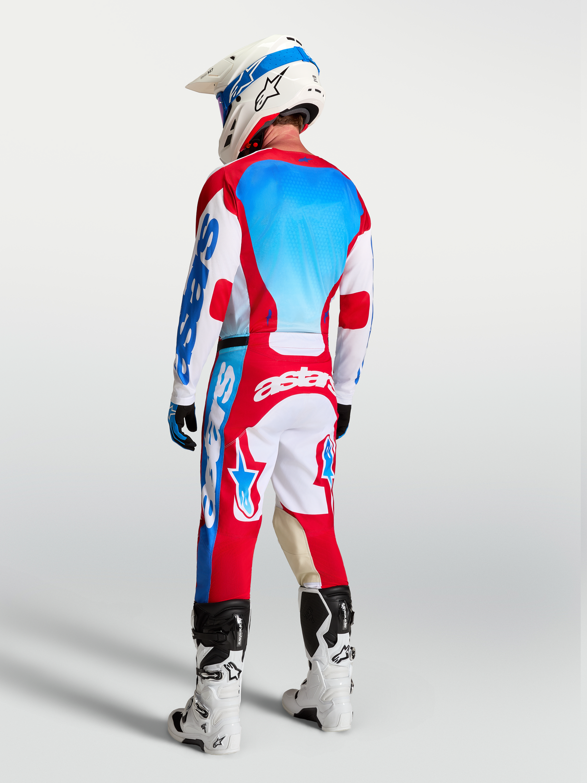 Alpinestars Pantaloni Racer Hunt AND Racer Hunt Gear Set, abbigliamento da motocross da uomo, rosso, bianco e blu, vista posteriore su pilota.