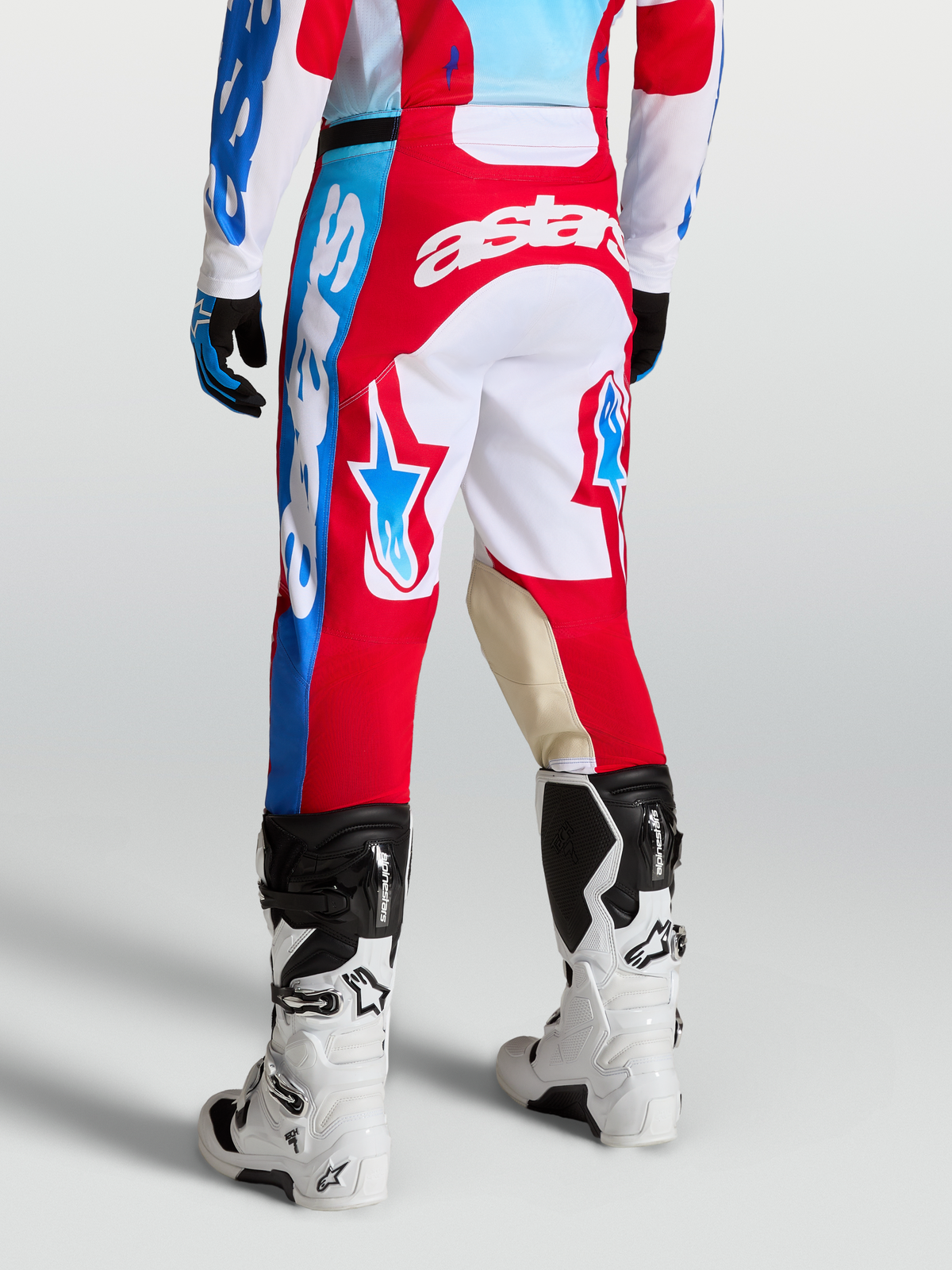 Alpinestars Pantaloni Racer Hunt, pantaloni motocross da uomo, rosso e bianco, con grafiche a stella e pannelli in pelle di capra sulle ginocchia, vista posteriore su modello