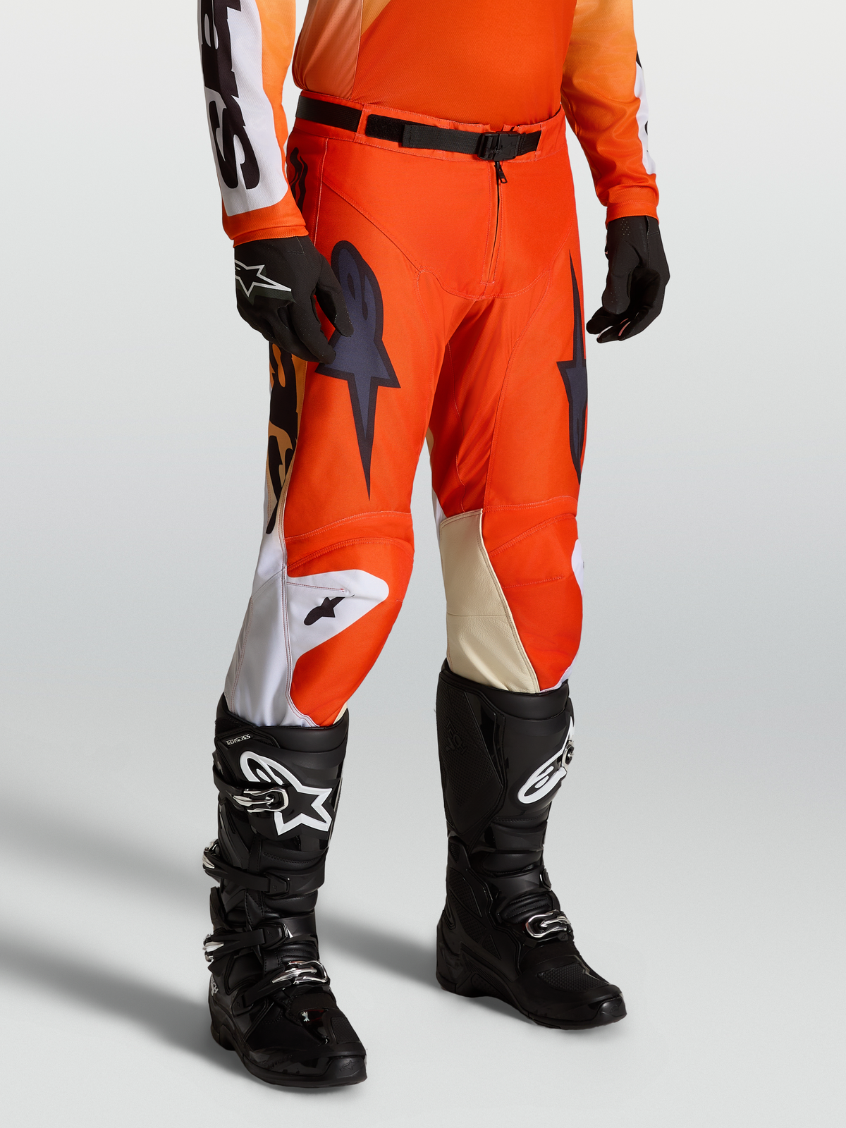 Alpinestars Pantaloni Racer Amber, pantaloni motocross da uomo, rosso e nero, polyfabric 600D resistente con inserti in pelle, chiusura magnetica SX2, abbinati a stivali Tech Series e guanti neri.