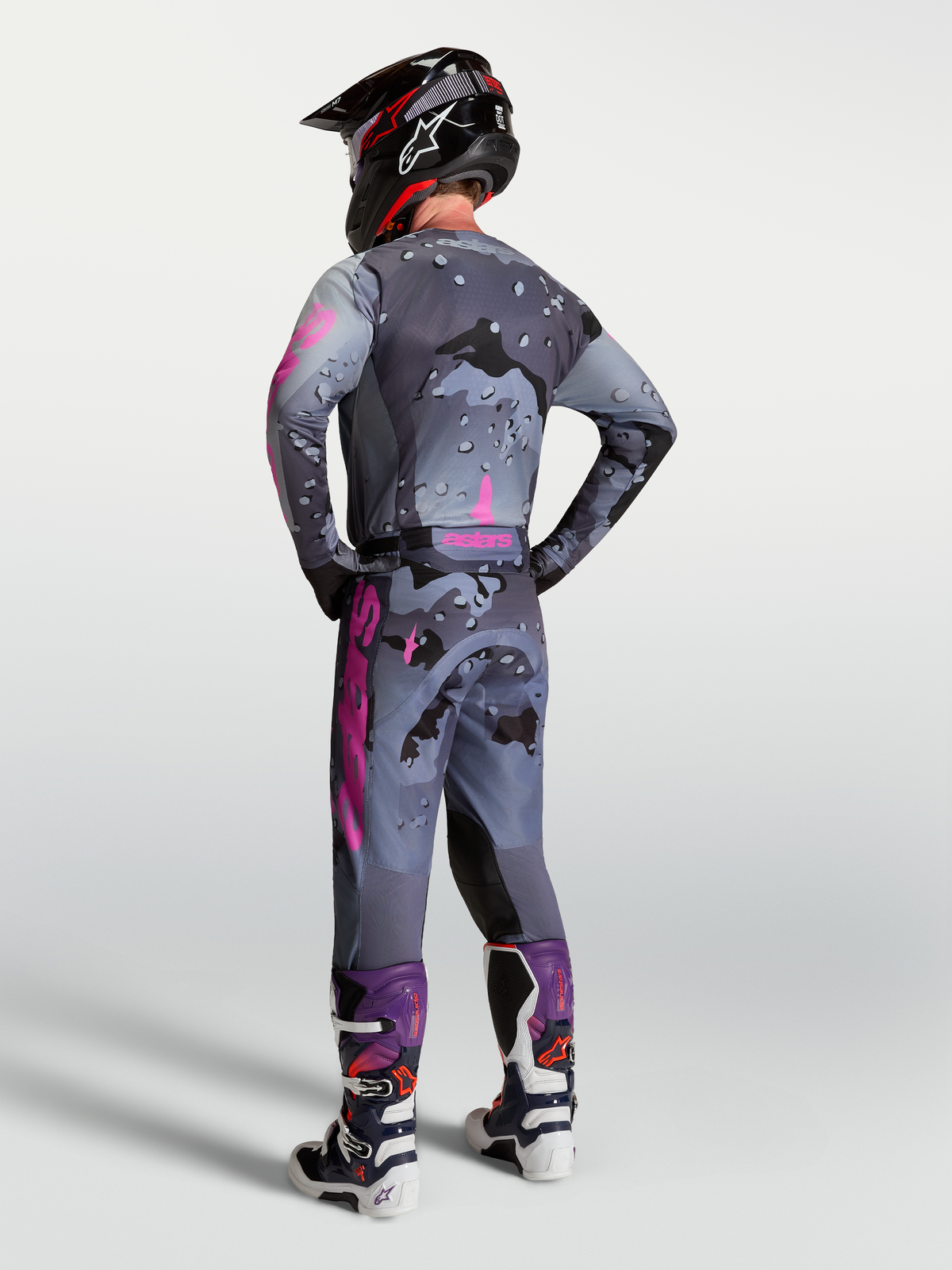 Alpinestars maglia Racer Lone e completo MX da uomo, grigio camo e viola, vista posteriore con pantaloni e stivali coordinati.