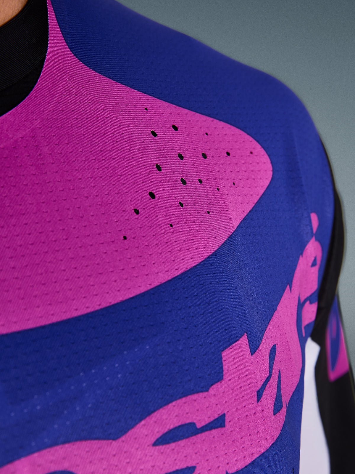 Alpinestars 2026 Techstar Knif Jersey, maglia da motocross, nero, grigio chiaro e viola, primo piano del petto con perforazioni tagliate al laser e tessuto elasticizzato traspirante per una ventilazione superiore