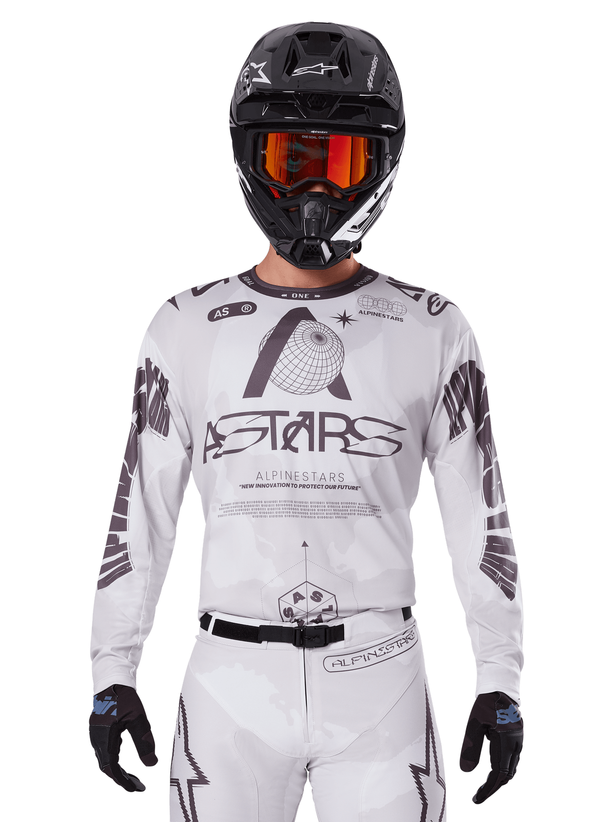 Alpinestars 2025 Racer Hollow Jersey, maglia da motocross bianca e nera, indossata con pantaloni MX bianchi coordinati e un casco nero con maschera arancione, caratterizzata da branding Alpinestars e grafiche a globo, abbigliamento professionale per corse fuoristrada