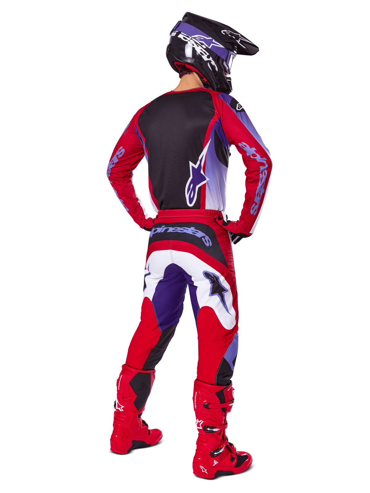 Pilota di motocross visto da dietro che indossa il completo Alpinestars 2025 Fluid Wurx, maglia Purple Bright Red con pannello posteriore nero, pantaloni da motocross coordinati con accenti bianchi e viola, stivali rosso brillante e casco nero, abbigliamento professionale da gara fuoristrada