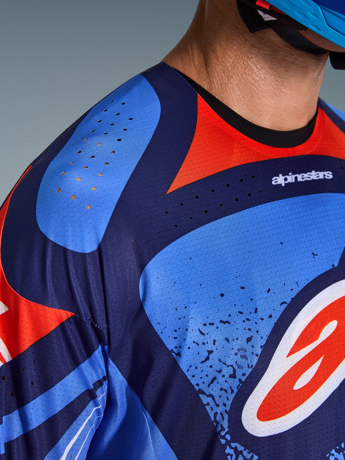 Alpinestars Techstar Nomur Jersey 2026, primo piano della zona del petto e della spalla, design blu navy e rosso con fori di ventilazione tagliati al laser, politessuto tecnico per prestazioni motocross