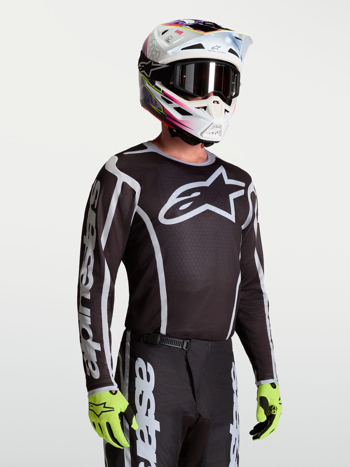 Alpinestars Maglia Fluid Apex V2, maglia da motocross da uomo, nero e argento, traspirante, indossata con casco.