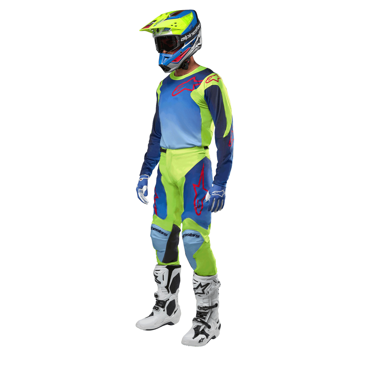 Alpinestars Racer Hoen Jersey 2024, maglia da motocross, giallo fluo e blu night navy, indossata da un pilota con pantaloni coordinati, casco e stivali bianchi, abbigliamento professionale da gara per guida fuoristrada