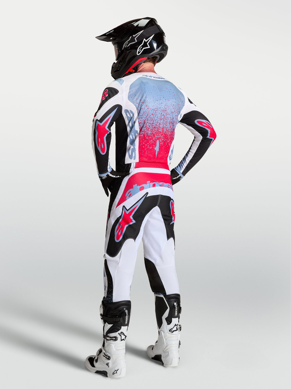 Alpinestars completo MX Fluid Drag 2027, completo da motocross da uomo nero, bianco e rosso con grafiche effetto spray.