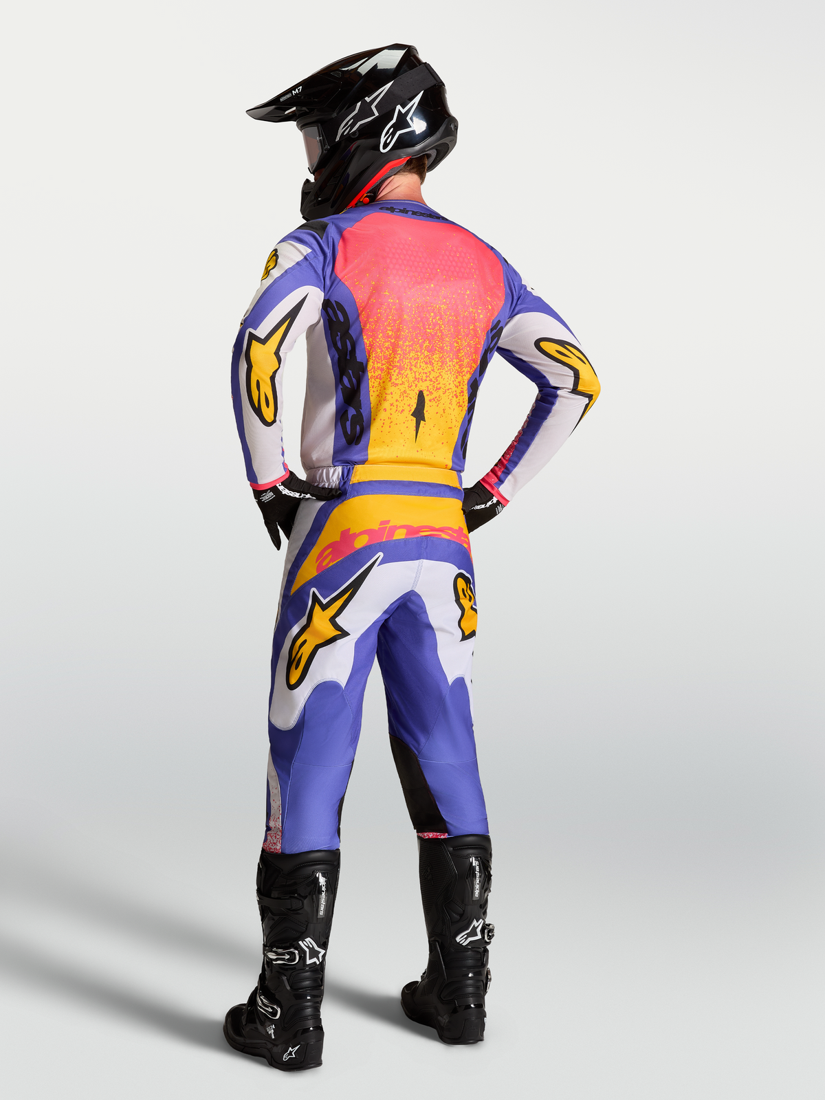 Alpinestars Fluid Drag Gear Set, maglia e pantaloni da motocross uomo, blu e lilla chiaro con accenti oro iris, visto dal retro.
