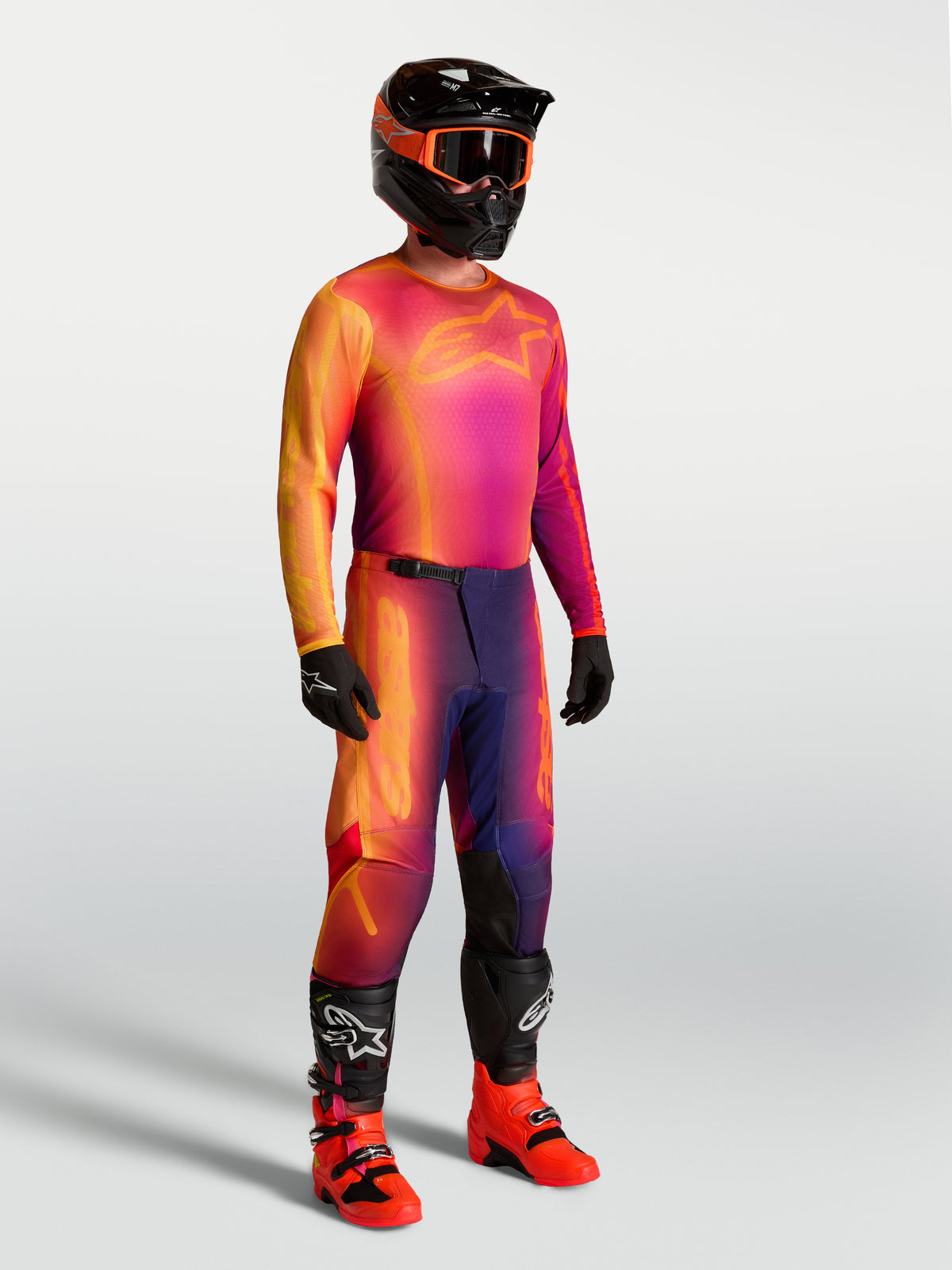 Alpinestars Maglia Fluid Kepler, maglia da motocross da uomo viola e arancione, con abbigliamento da gara coordinato.