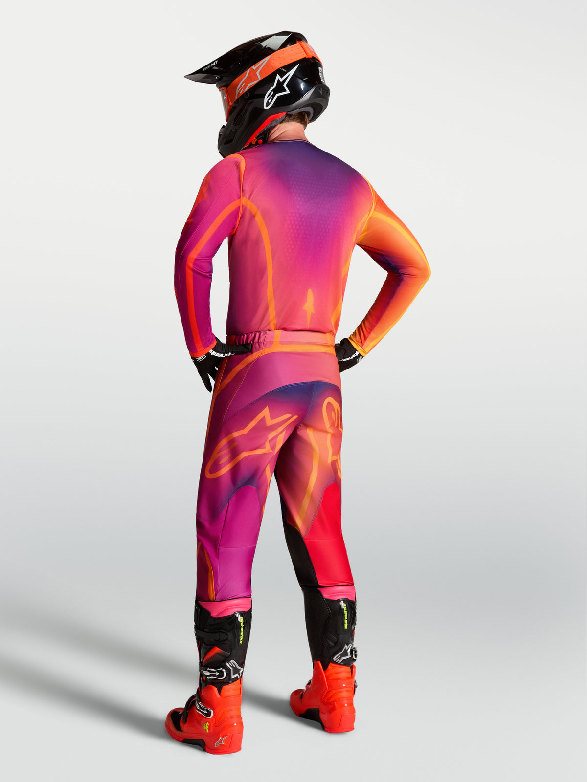 Alpinestars maglia Fluid Kepler, maglia da motocross viola e arancione, vista posteriore su un pilota