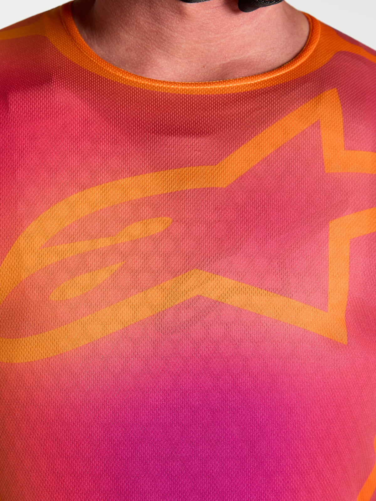 Alpinestars Maglia Fluid Kepler, primo piano del design viola e arancione sul petto con l'iconico logo A-star arancione.
