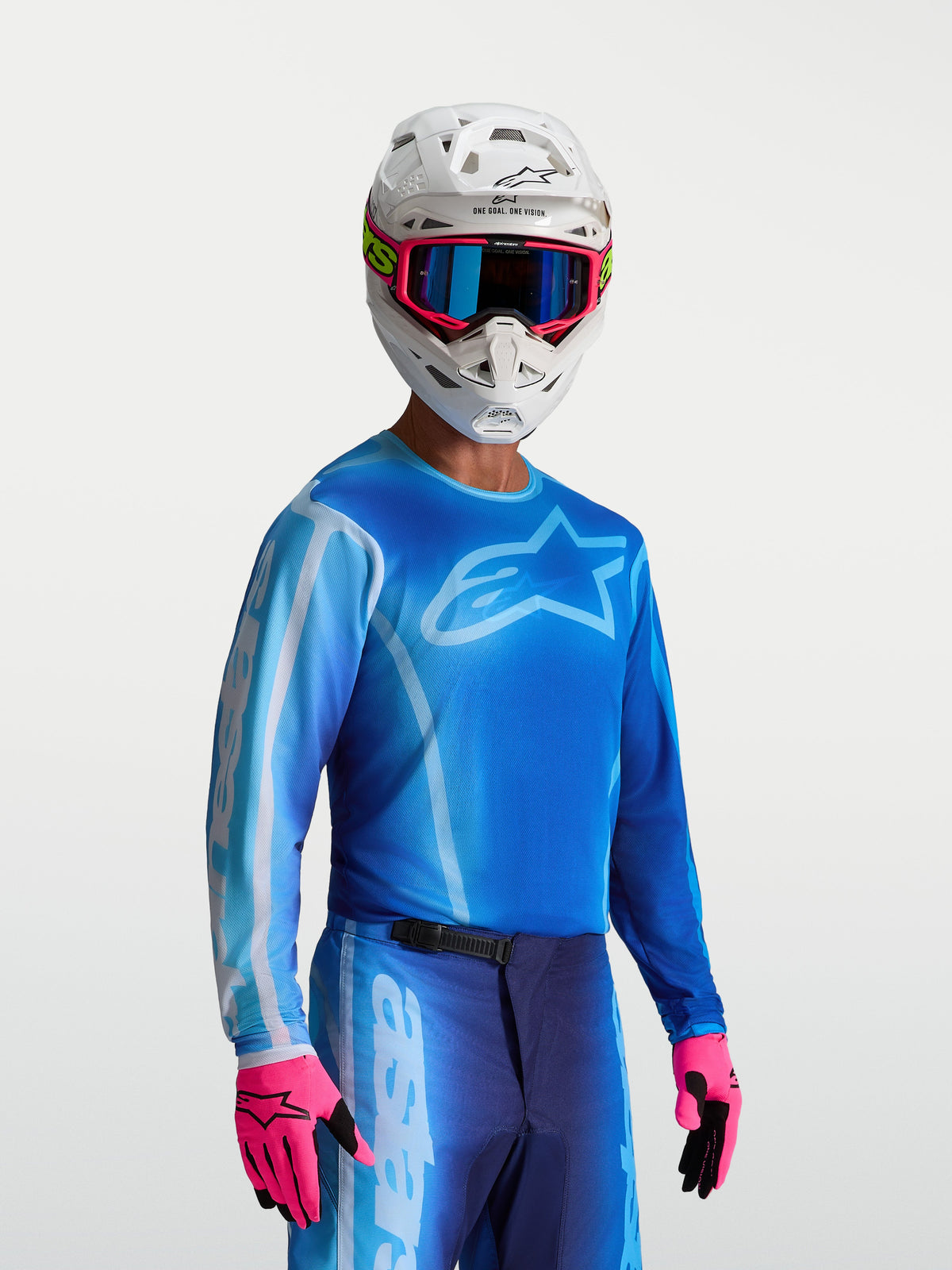 Alpinestars Maglia Fluid Kepler, maglia motocross da uomo, blu UCLA e blu chiaro, indossata con casco bianco e guanti rosa, tessuto traspirante e leggero per motocross e off-road