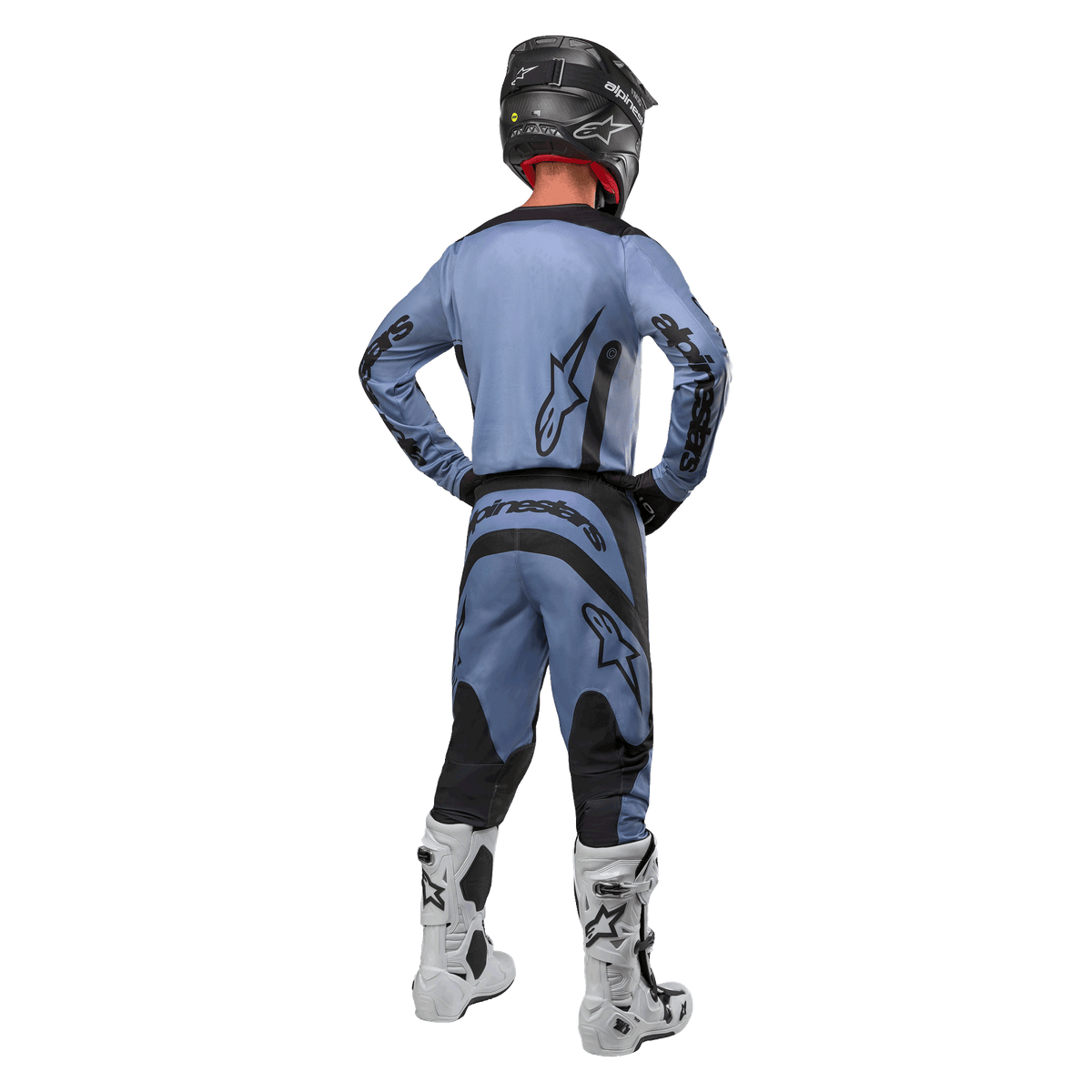 Pilota di motocross visto da dietro che indossa la maglia Alpinestars Fluid Lurv 2024 e i pantaloni coordinati in azzurro e nero, con branding nero sul retro e sulle maniche, abbinati a un casco nero e stivali bianchi.