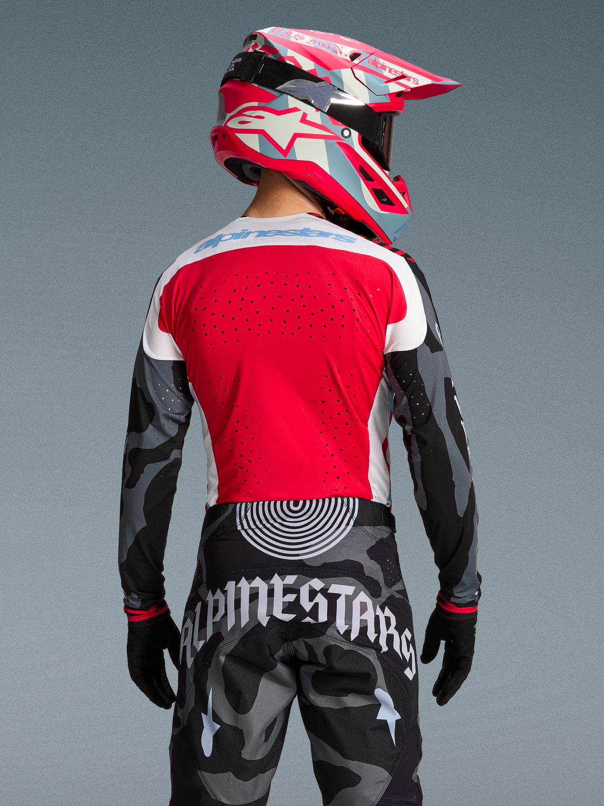 Maglia Techstar Beast Coast Edizione Limitata, design rosso e mimetico, pantaloni coordinati e casco MX, vista posteriore.