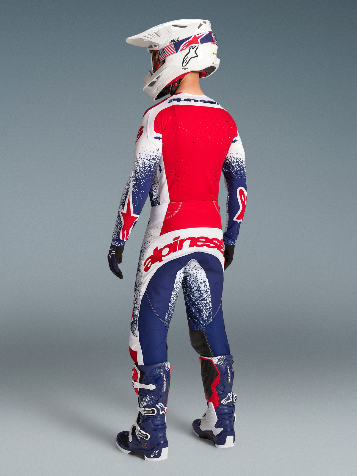 Alpinestars Techstar Unity Maglia, maglia da motocross da uomo in edizione limitata, rossa, bianca e blu, vista posteriore con pannelli ventilati e vestibilità racing.