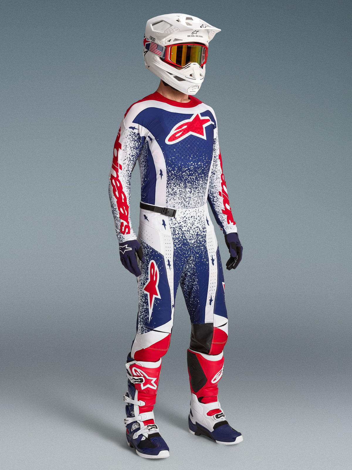 Alpinestars Techstar Unity maglia, maglia da motocross da uomo in edizione limitata, bianca, rossa e blu, vestibilità racing, indossata su modello con set completo coordinato per prestazioni off-road