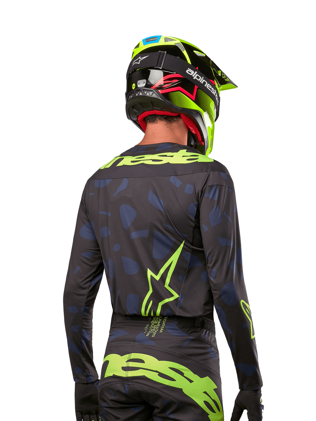Vista posteriore di un pilota di motocross con maglia Alpinestars 2024 Techstar Rantera in Black Navy Yellow Fluo, caratterizzata da loghi giallo fluo prominenti sulla schiena, abbinata a pantaloni coordinati e casco giallo neon per un look completo da off-road.