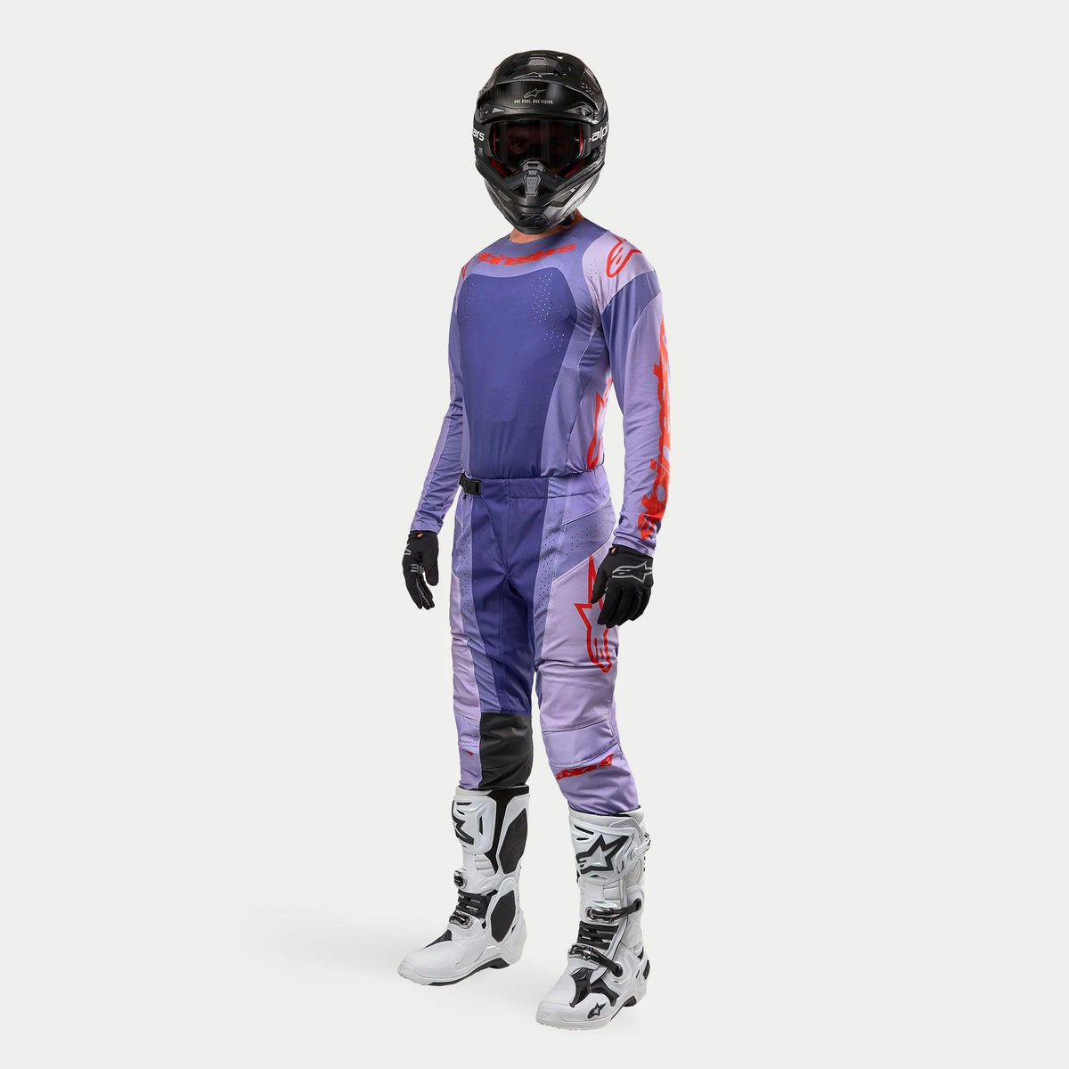 Abbigliamento completo da motocross Alpinestars Techstar Ocuri 2024, maglia e pantaloni coordinati viola e arancione acceso, casco nero, guanti neri e stivali bianchi con dettagli neri