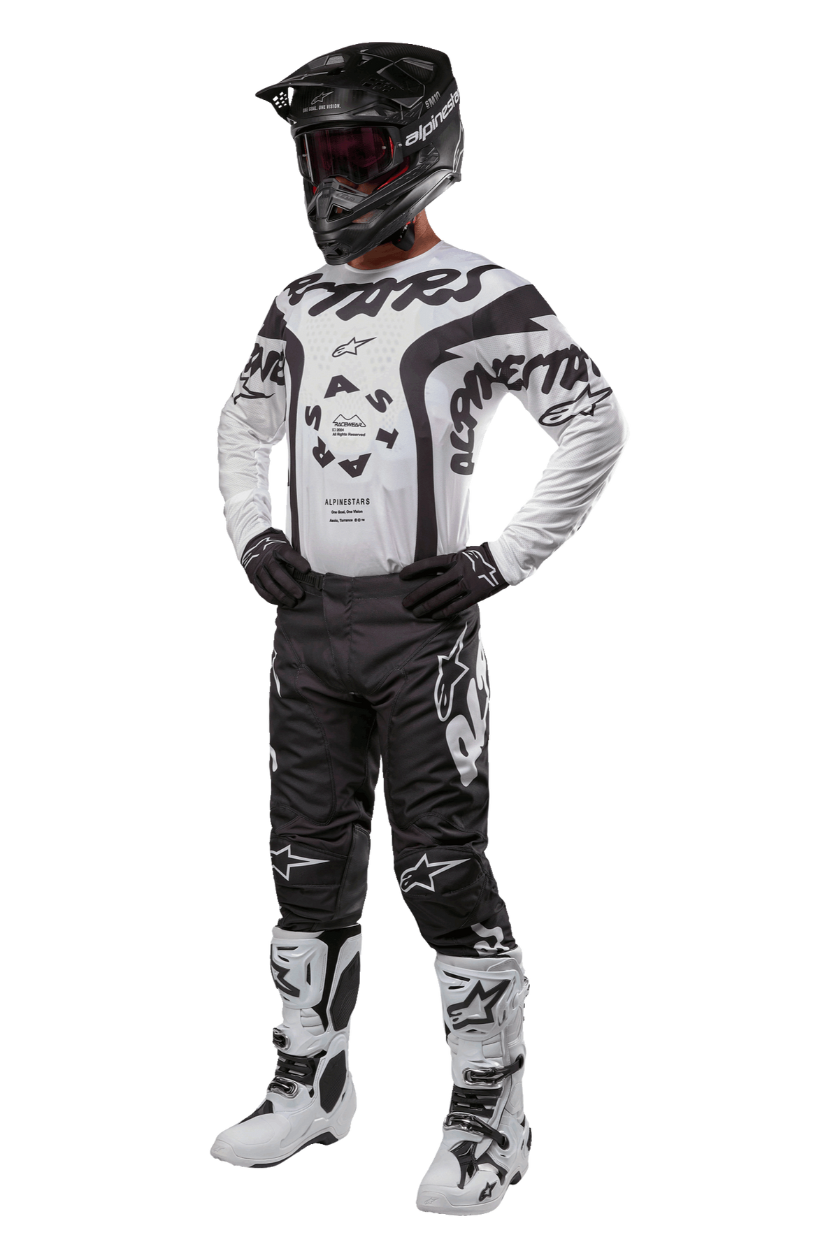 Pilota di motocross con abbigliamento completo Alpinestars, maglia Racer Hana 2024 in bianco e nero, pantaloni da motocross neri con loghi bianchi, casco nero, stivali da corsa bianchi e neri e guanti neri, completo da gara professionale per fuoristrada