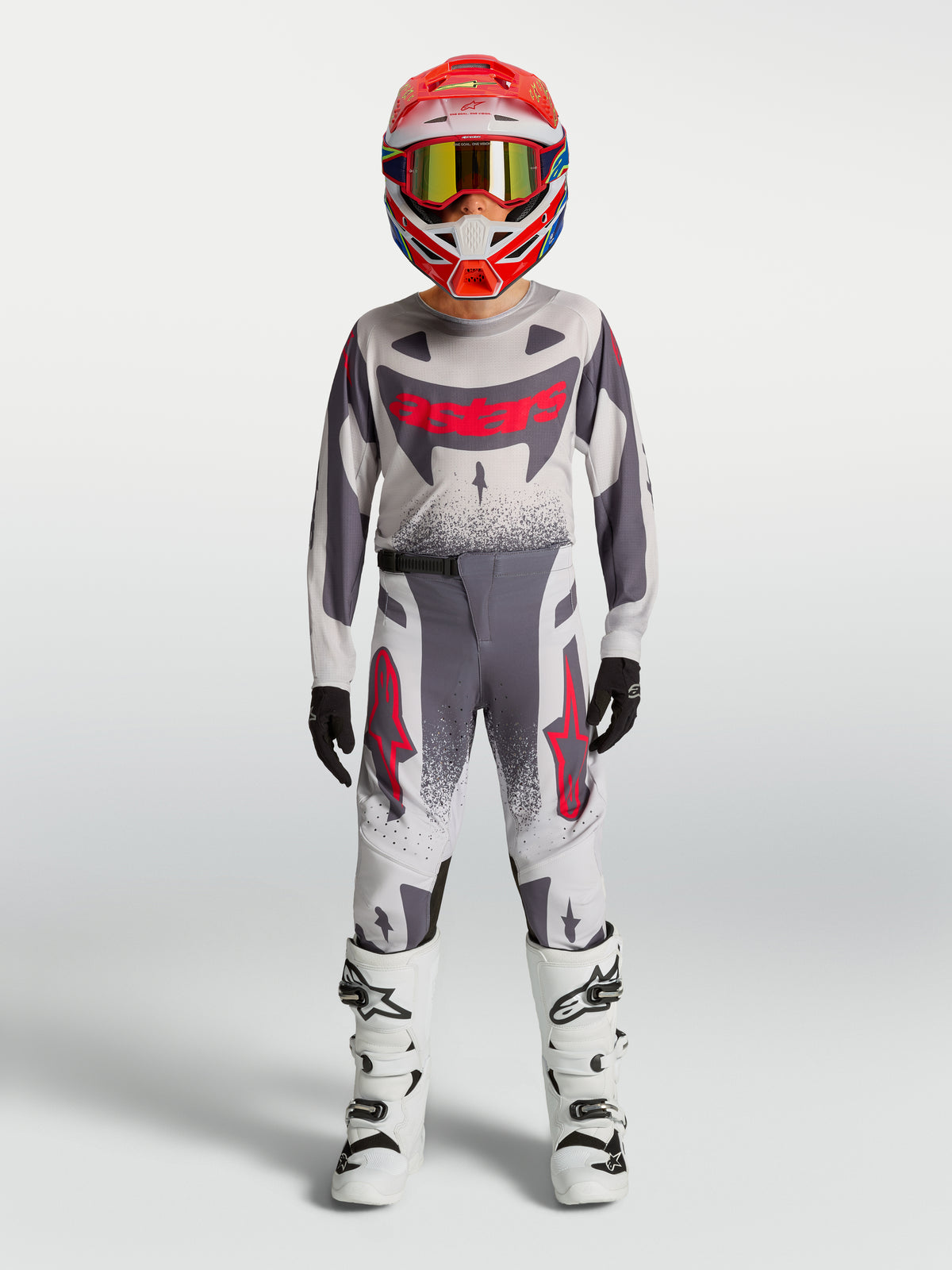 Alpinestars Maglia e Gear Set Supertech Swan Ragazzo 2027, completo da motocross grigio e bianco con dettagli rossi.
