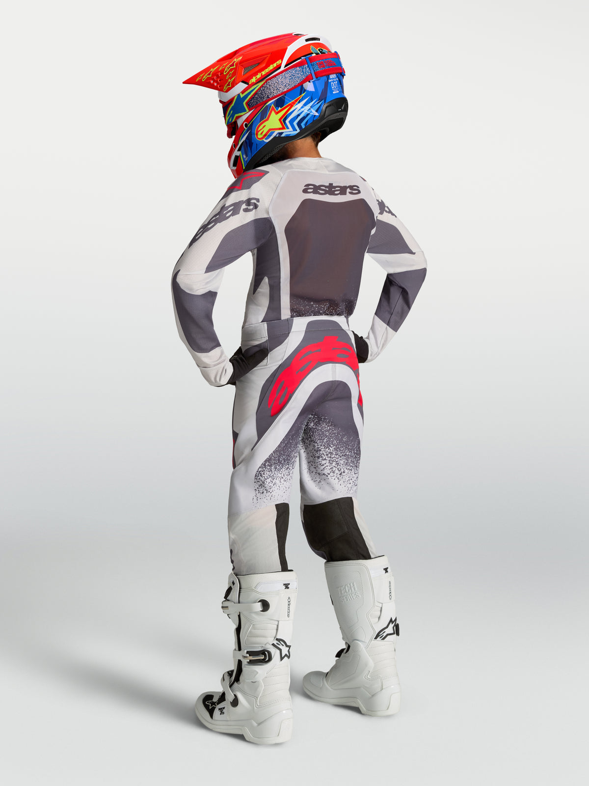 Alpinestars maglia Supertech Swan ragazzo e gear set, completo motocross grigio e bianco con accenti rossi, vestibilità gara.