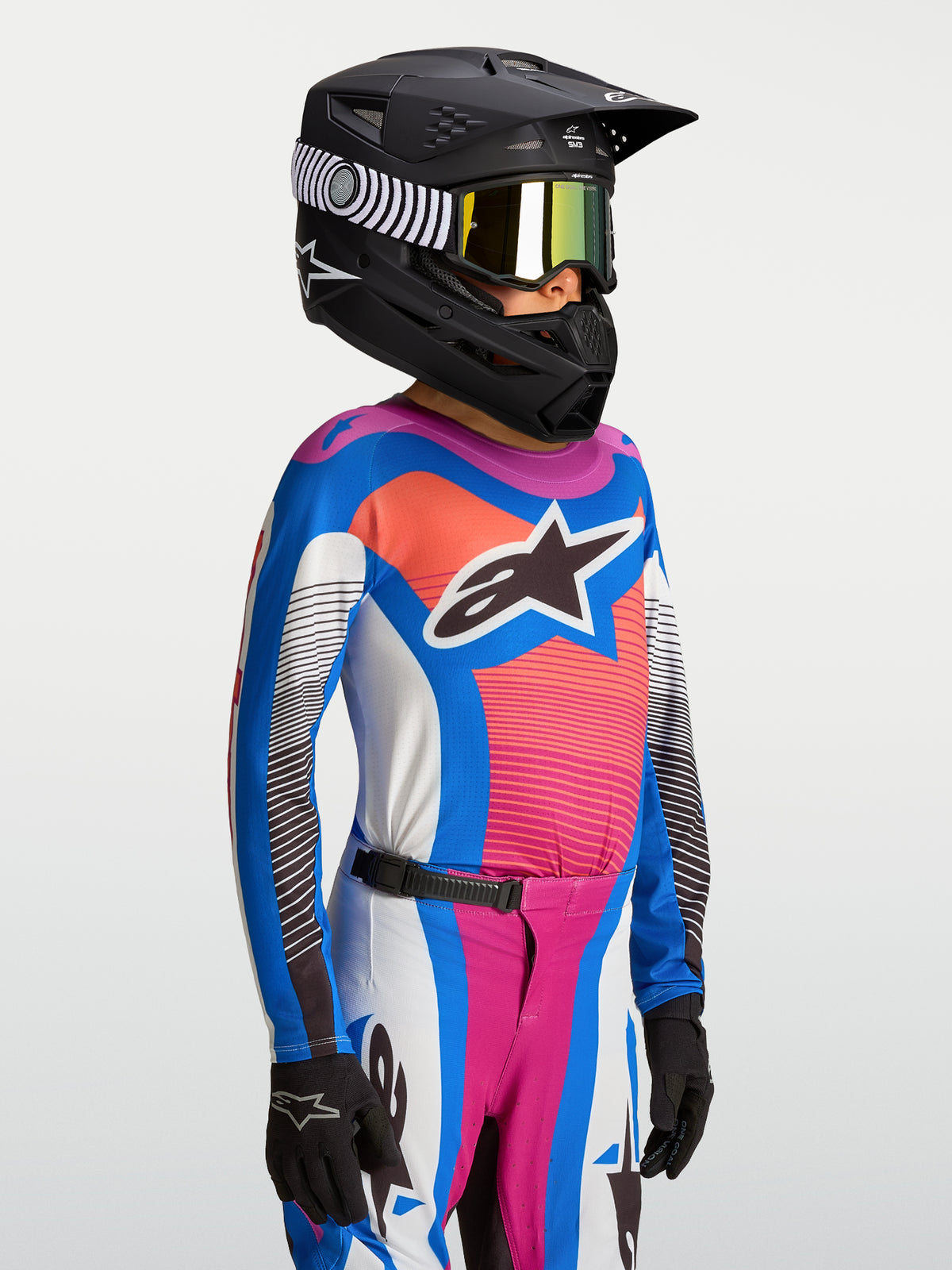 Alpinestars maglia Supertech Maven ragazzo, maglia da motocross blu e corallo traspirante, indossata con casco nero da gara
