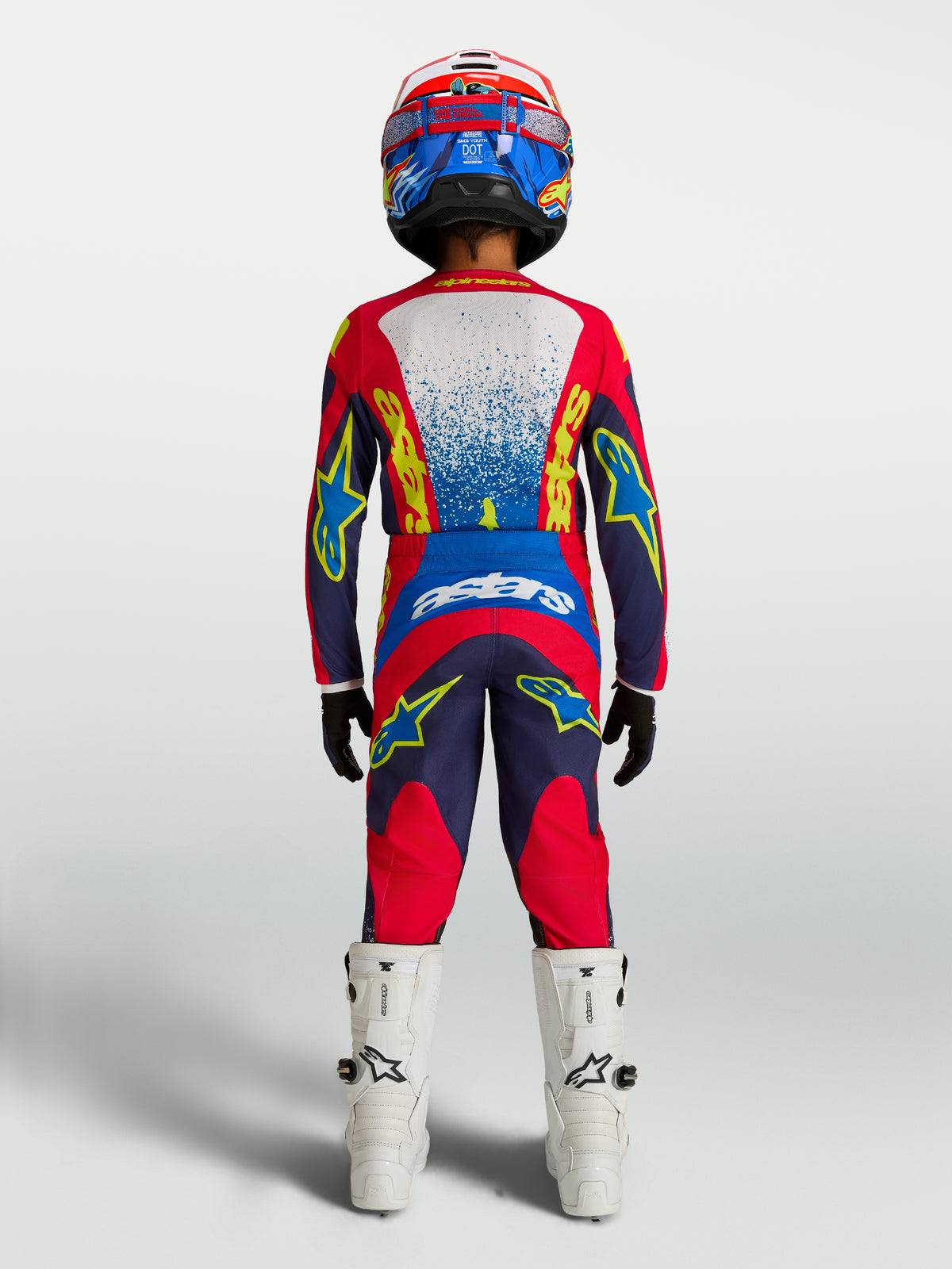Alpinestars maglia Fluid Drag ragazzo 2027, completo motocross blu navy e rosso fuoco, vista posteriore su giovane pilota.