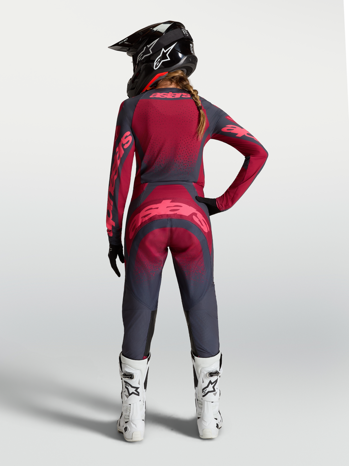 Alpinestars maglia Stella Techstar Swan, completo da motocross da donna rosso e grigio scuro, vista posteriore su modella.