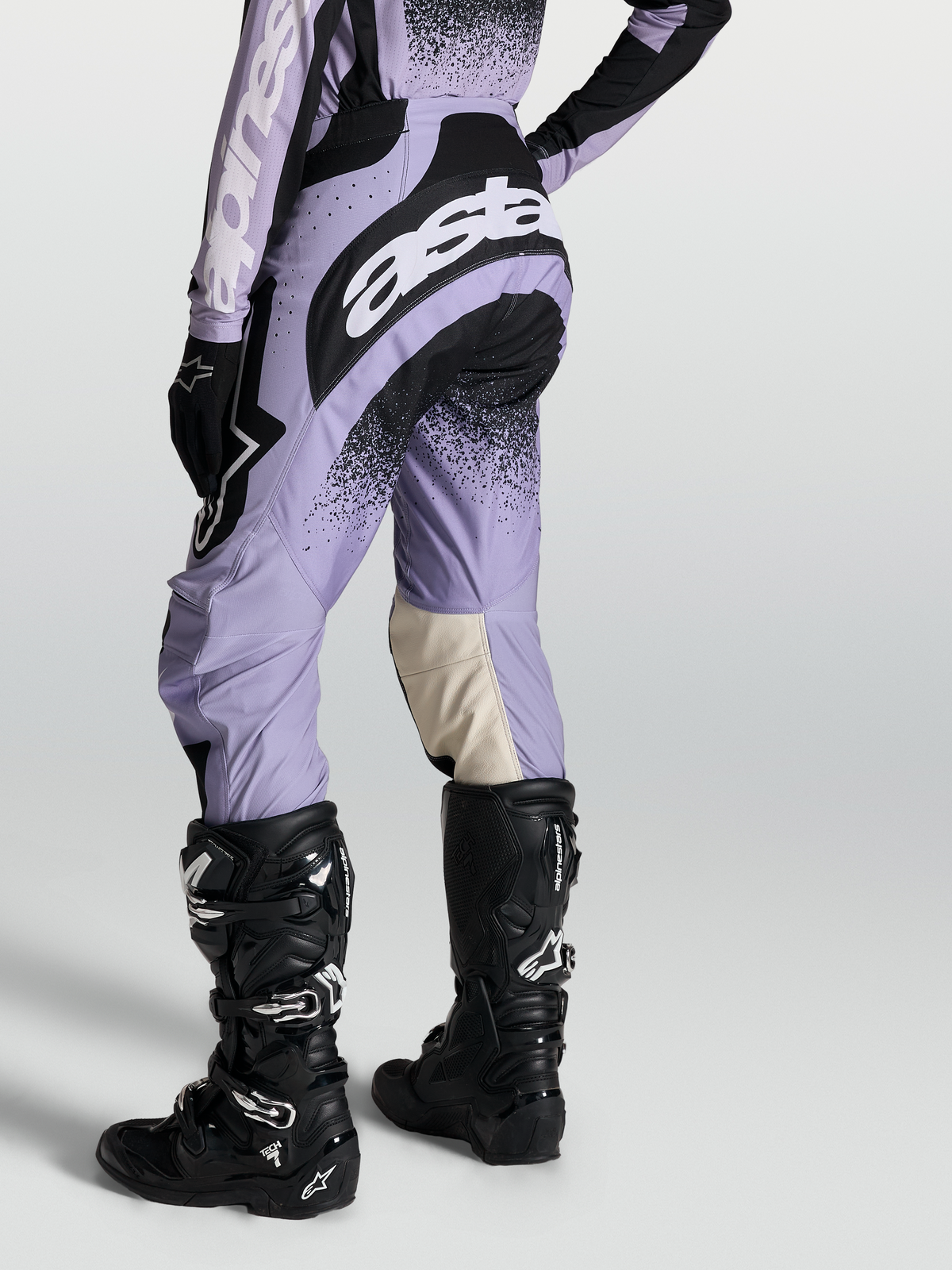 Alpinestars Pantaloni Stella Techstar Swan, pantaloni motocross da donna, viola chiaro e neri, indossati con stivali Tech 7.
