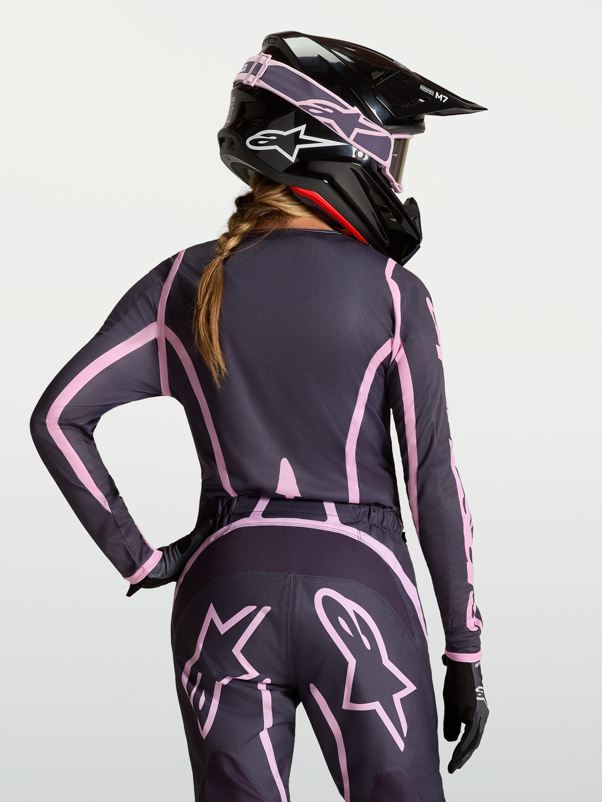 Alpinestars Maglia Stella Fluid Apex V2, maglia motocross da donna, grigio e rosa, vestibilità ergonomica con retro allungato, indossata con casco coordinato, abbigliamento tecnico off-road