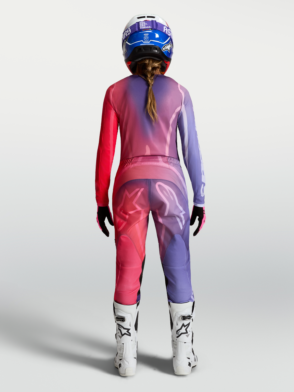 Alpinestars Maglia Stella Fluid Kepler, maglia da motocross per donna, viola e rosso, in poliestere traspirante, vista posteriore su modella con pantaloni e stivali coordinati.