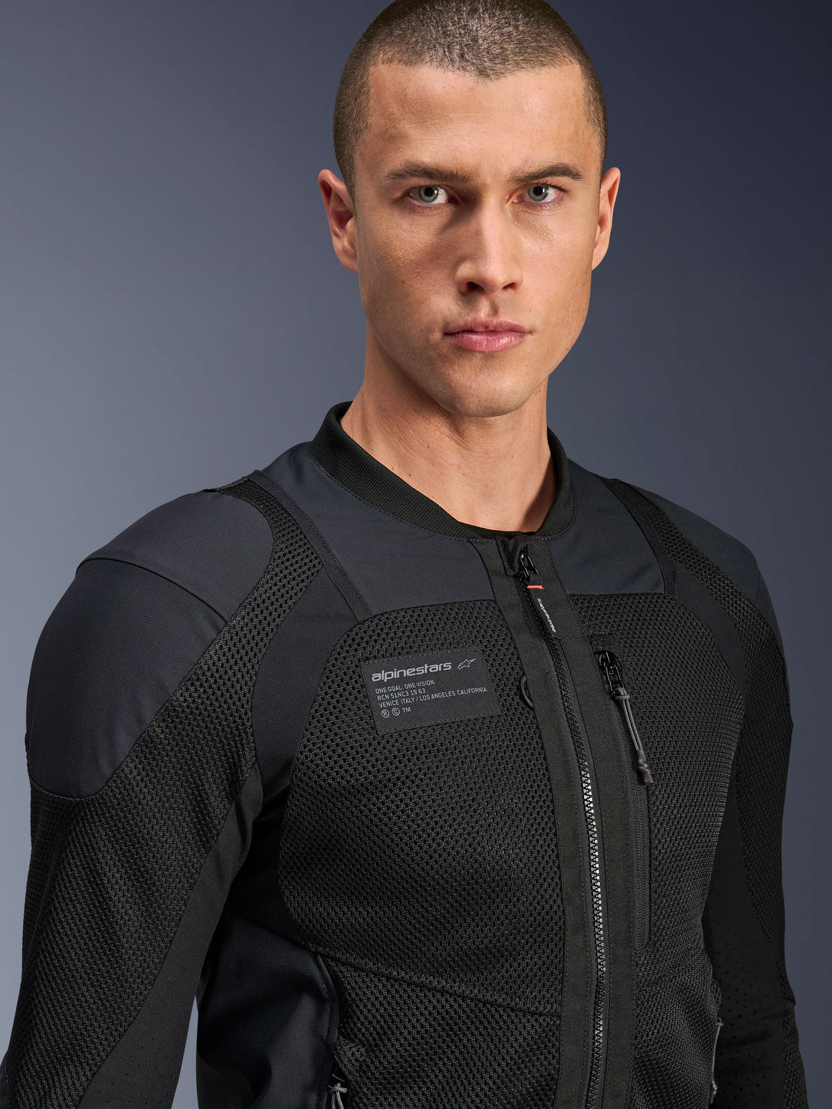 Giacca Alpinestars Troop-Air Pro, nero, giacca tecnica da moto ventilata e corazzata, primo piano che mostra la trama in mesh 2D e la patch del marchio sul petto.