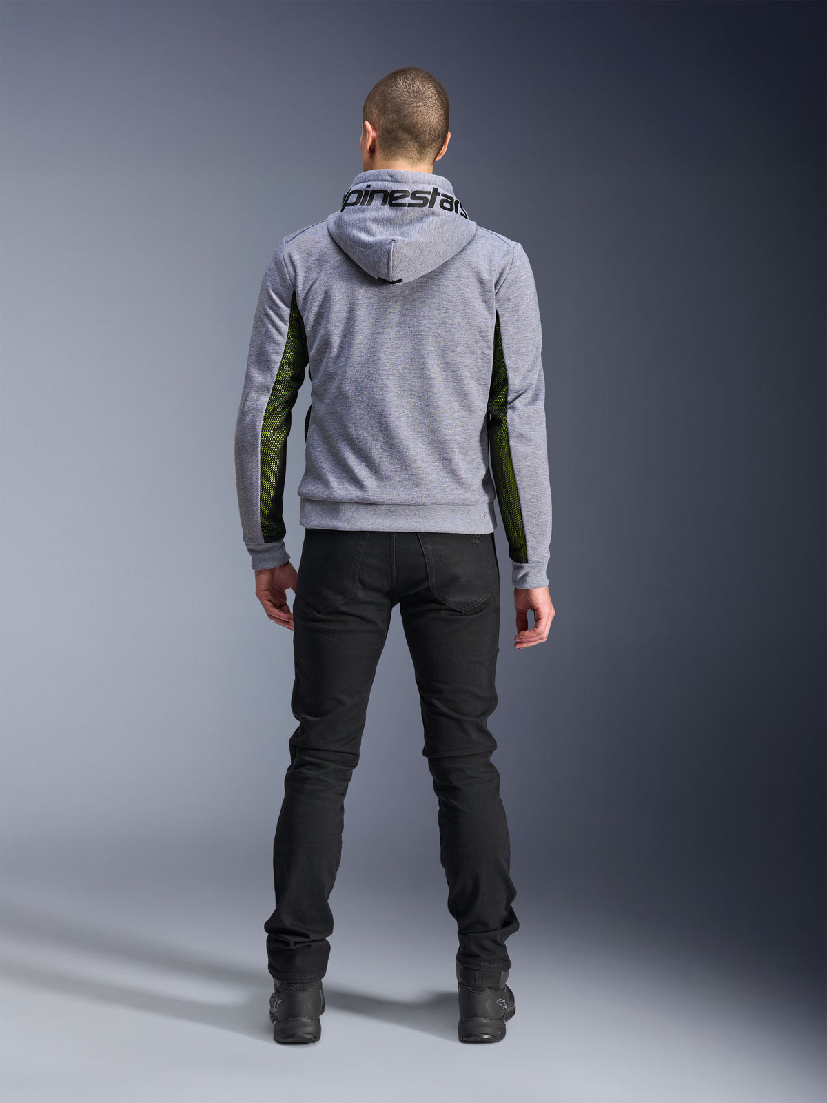 Alpinestars Chrome Air Sport Hoodie, Grigio Heather Nero, vista posteriore della felpa da moto con pannelli in mesh verde ad alto flusso sui lati e sulle maniche, costruzione in pile tecnico con marchio Alpinestars sul cappuccio, indossata con pantaloni neri