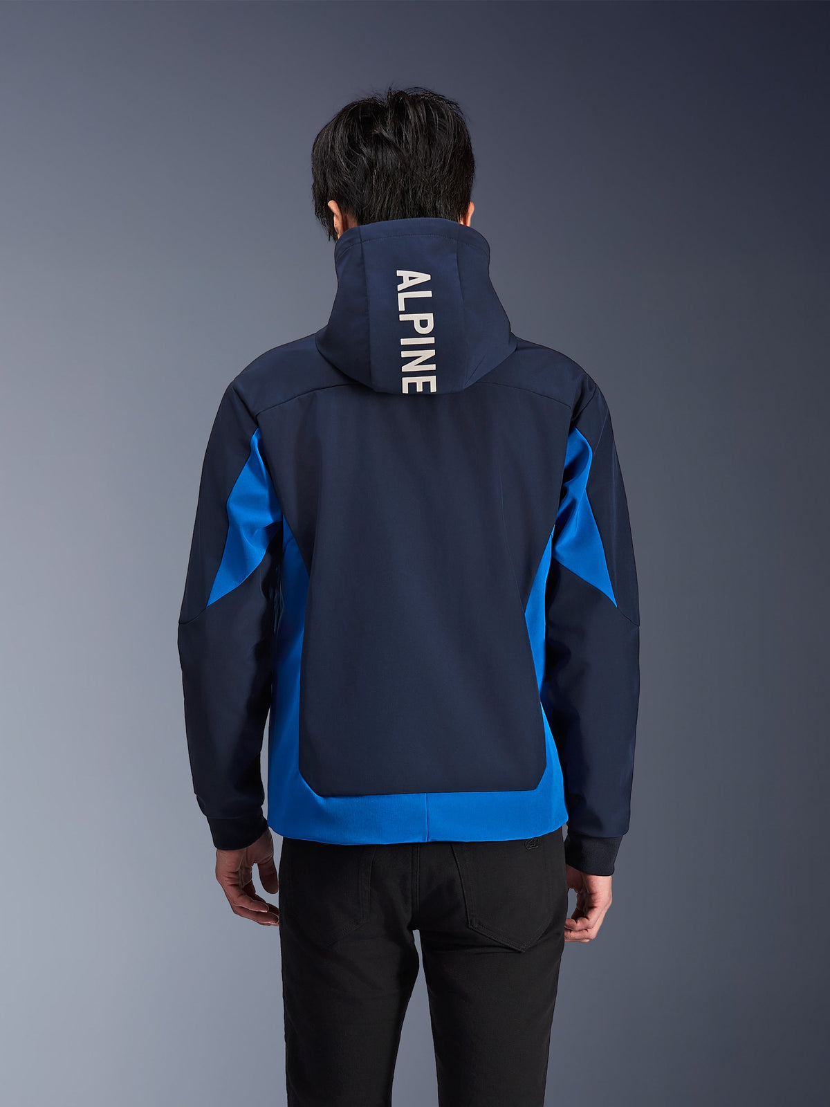 Alpinestars Radium Tech Hoodie, giacca da moto blu notte e blu reale, vista posteriore che mostra il marchio 'ALPINE' bianco sul cappuccio, abbigliamento urban performance con vestibilità atletica e pannelli di colore a contrasto