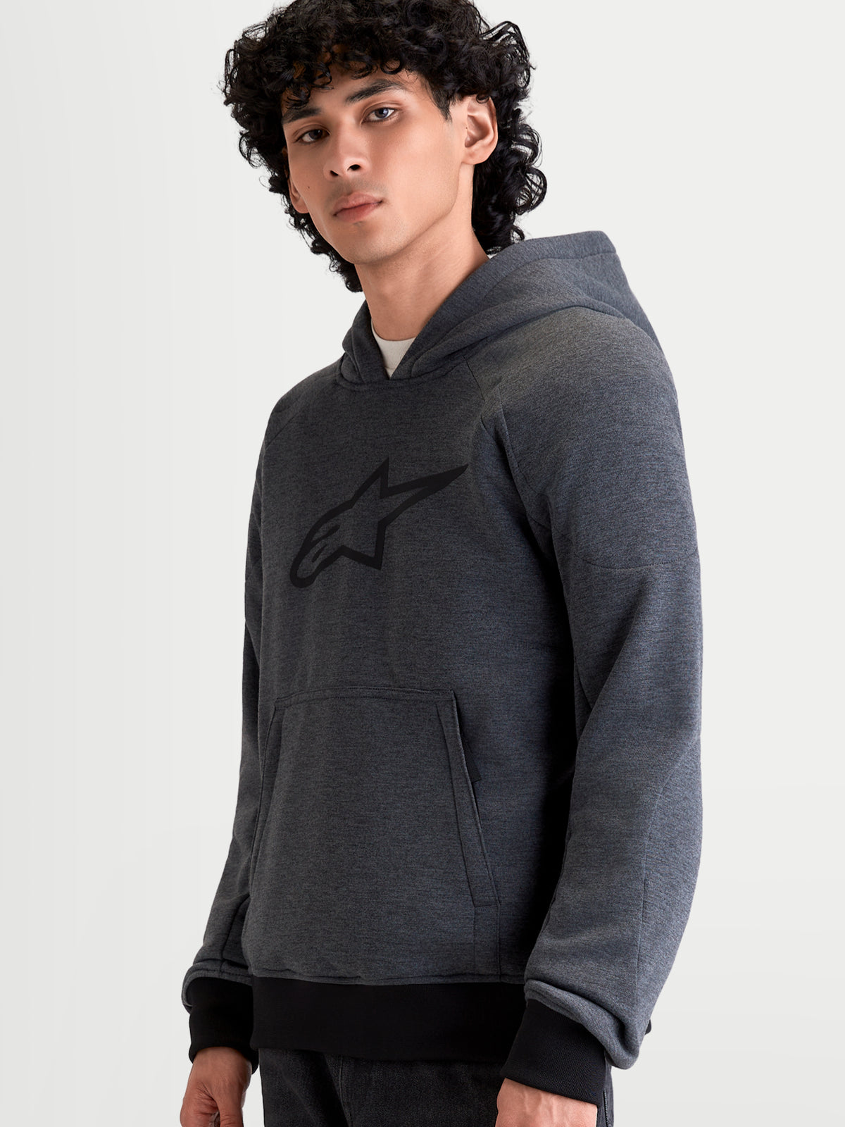 Alpinestars Felpa Con Cappuccio Ageless, felpa da moto urbana da uomo in grigio asfalto melange con tasca a marsupio frontale e cappuccio fisso, indossata da un modello