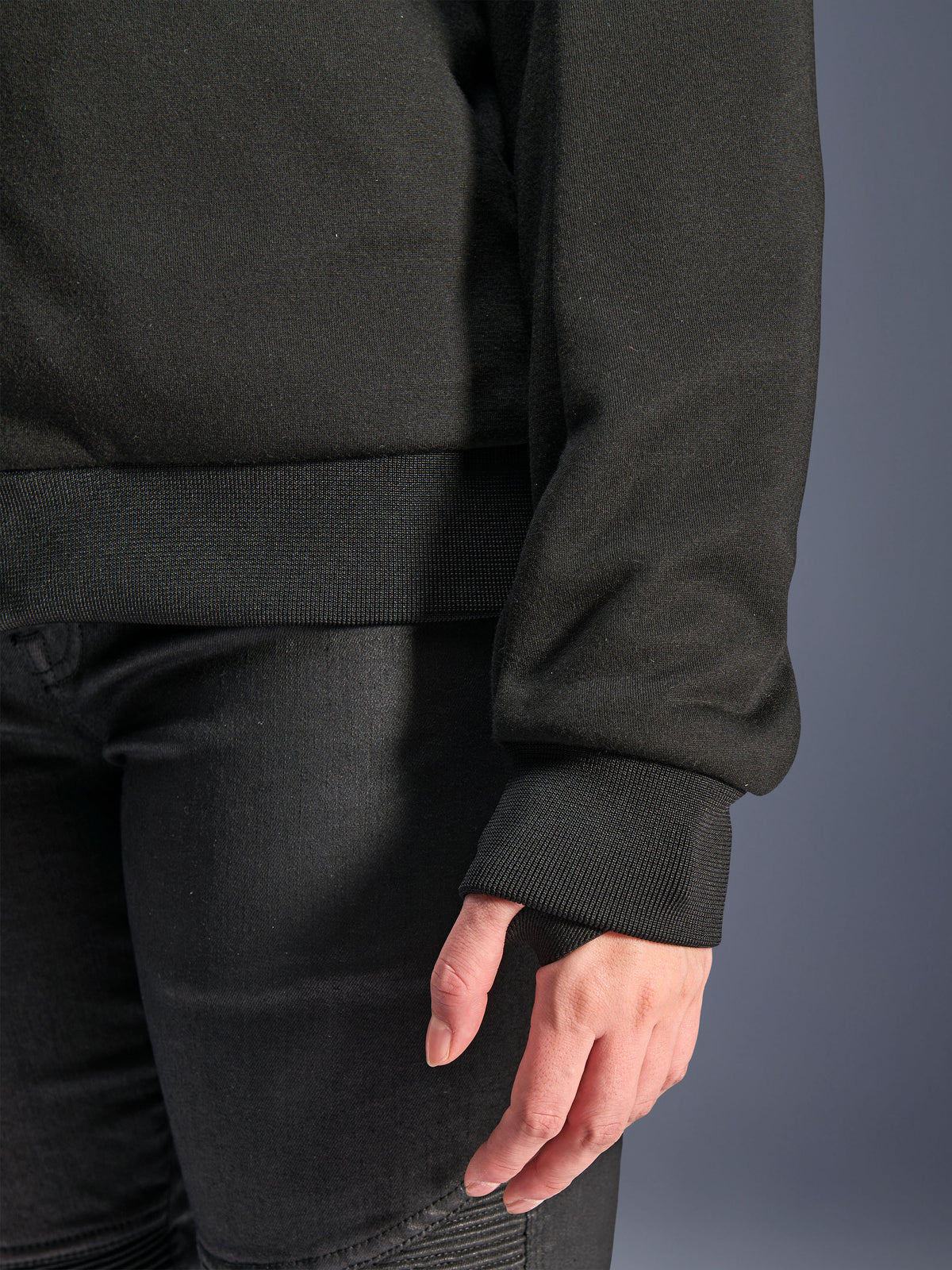 Alpinestars Stella Chrome V2 Sport Hoodie, nero, primo piano del polsino a coste con foro per il pollice e orlo in vita a coste, materiale in pile tecnico per la guida urbana in moto