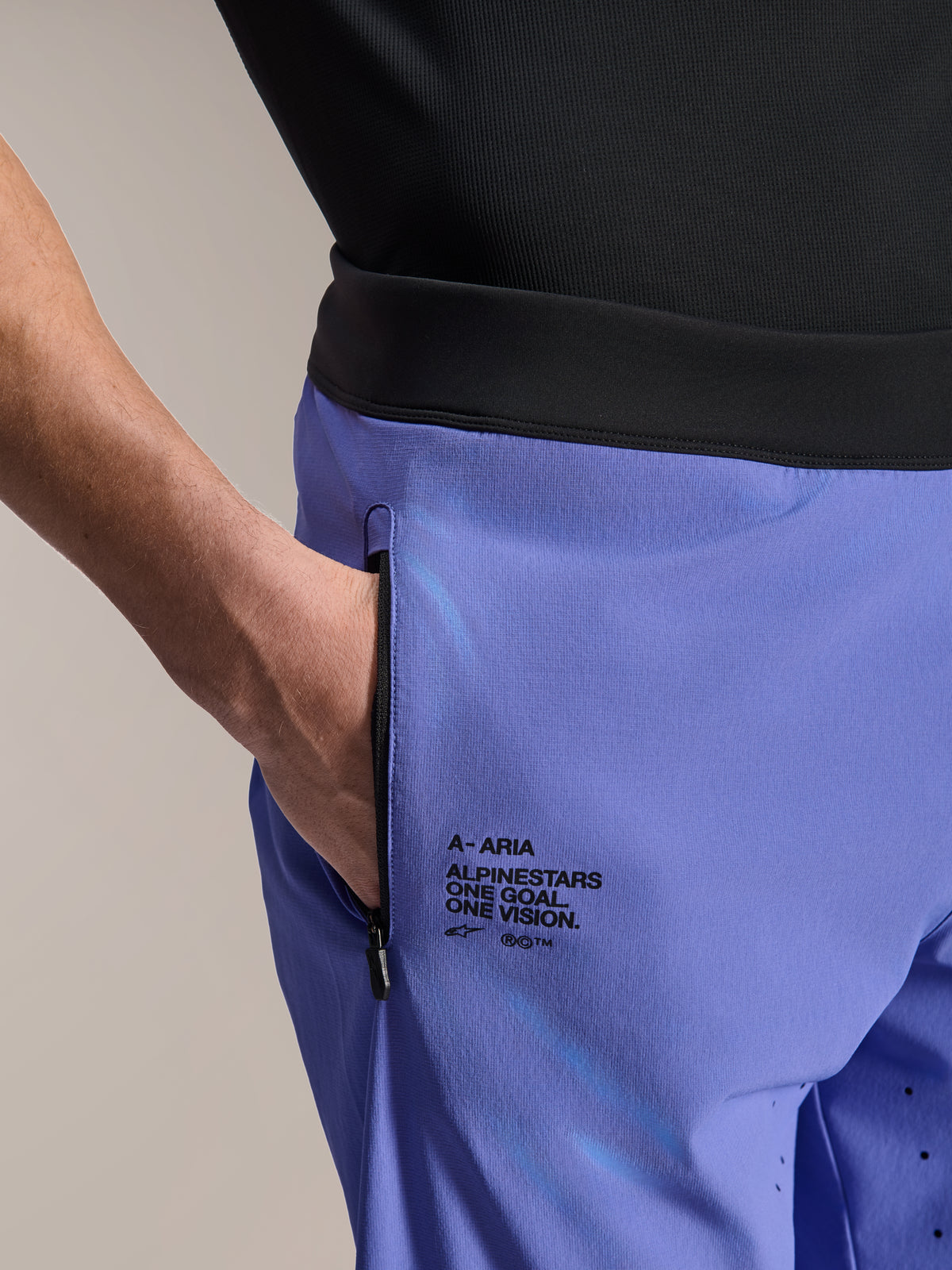 Alpinestars A-Aria Lite Short, pantaloncini MTB, Baja Blue, primo piano della tasca anteriore con zip e del marchio laterale con testo "One Goal. One Vision.", fascia nera in vita e tessuto tecnico per mountain bike