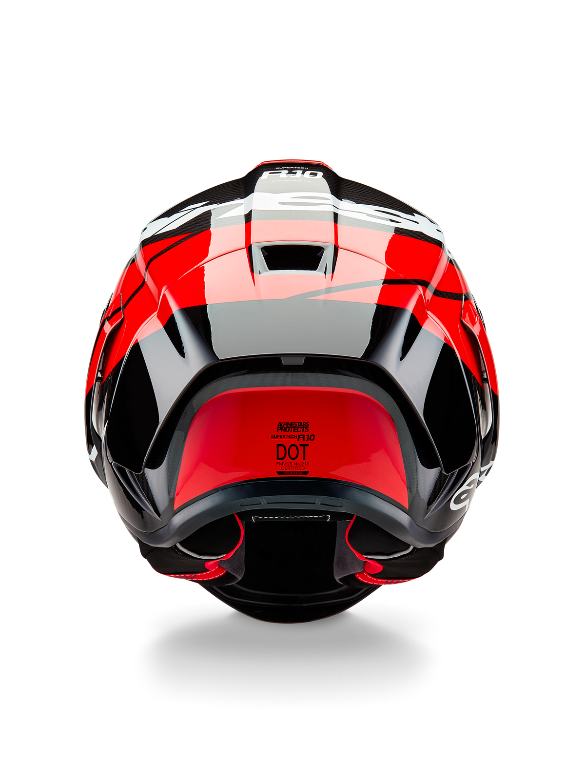 Casco Alpinestars Supertech R10 Element, vista posteriore, nero carbonio con accenti rosso brillante e bianco lucido, con spoiler posteriore aerodinamico, prese d'aria di scarico ed etichetta di certificazione DOT, design elegante di ispirazione racing con dettagli in fibra di carbonio