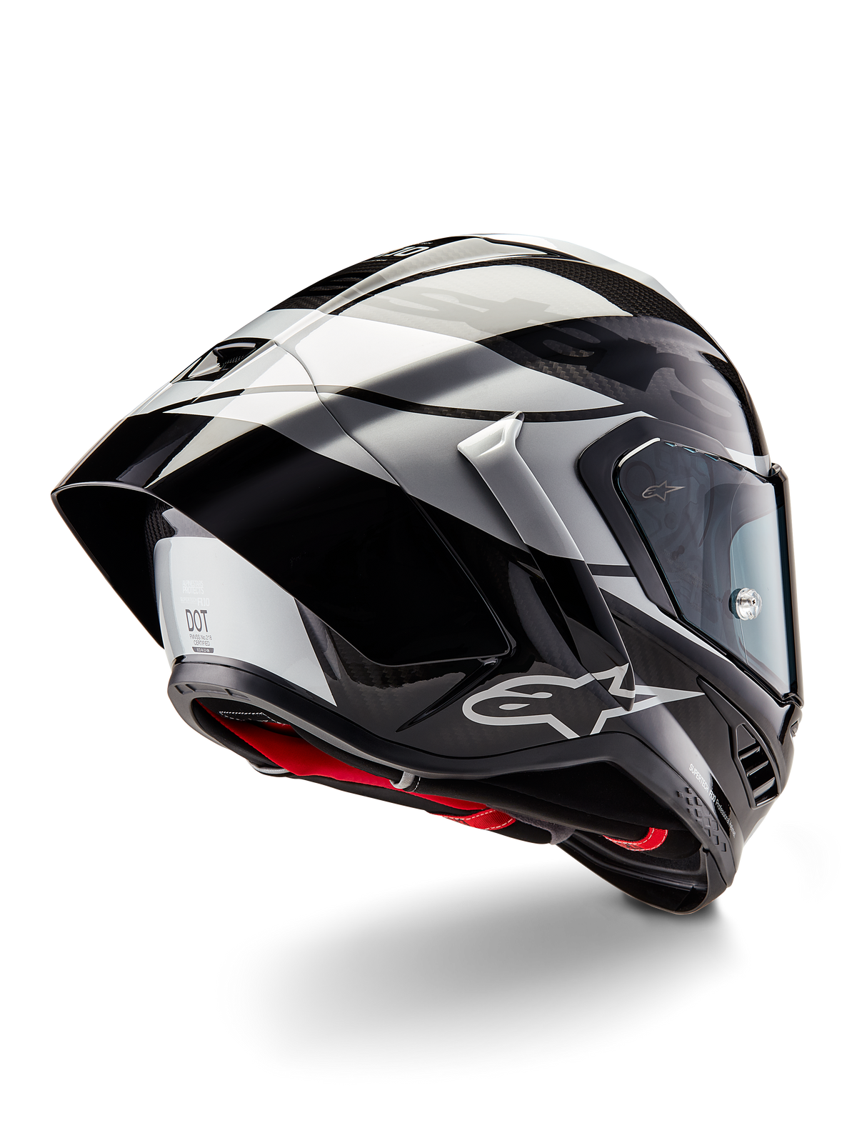 Casco Alpinestars Supertech R10 Element, Nero Carbonio Argento Nero Lucido, vista posteriore a tre quarti che mostra il profilo aerodinamico da corsa, calotta in fibra di carbonio lucida con grafiche geometriche grigie e nere, logo Alpinestars e imbottitura interna rossa